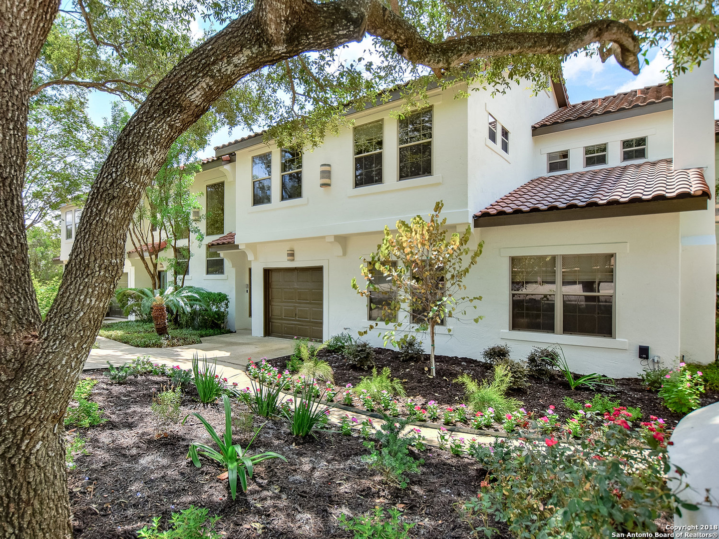 Luxurious townhome-style living in the heart of Alamo Heights! Classic architecture in  quiet, shady surroundings remodeled w/the finest of finishes so convenient to shopping, arts & dining! Enjoy nature in the largest private patio area of all units. Fine finishes to include wood & marble flooring; chef's kitchen with miles of quartzite counters & ample cabinets. The floorplan is open to windowed, airy living spaces.  New plantation shutters.   Elegant bedroom suites provide roomy closets & stunning en suite luxury baths. Two car rear-entry garage newly tiled and outfitted with a Tesla electric car charger. NEST thermostats, CAT 5, fiber. AHISD.
