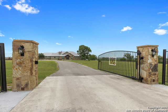 LOCATED JUST 7 min from New Braunfels, 12 min from San Marcos and just minutes from Seguin. This beautiful custom-built Hill Country home sits on over 18 acres & features close to 2600 sq ft w/ 3 bedrooms, 2 1/2 baths, the additional upstairs bedroom/bonus room with nearly 500 sq ft that is not listed in taxes. Some of the many features include gorgeous wood floors that are from the original 1904 Farmhouse, exposed beams, floor to ceiling stone fireplace and an antique antler light fixture. The office is off the living room w/custom built in desk & shelves, and a built-in climate-controlled gun safe. The kitchen features custom cabinets, custom center island, granite countertops. Perfect for entertaining is the outdoor patio w/wood burning fireplace. The man cave is perfect for poker night and was also made from wood from the old barn. The 48x40 barn includes a tack room, shop and pens. Chicken coop, dog kennel, garden and pond also on the property!