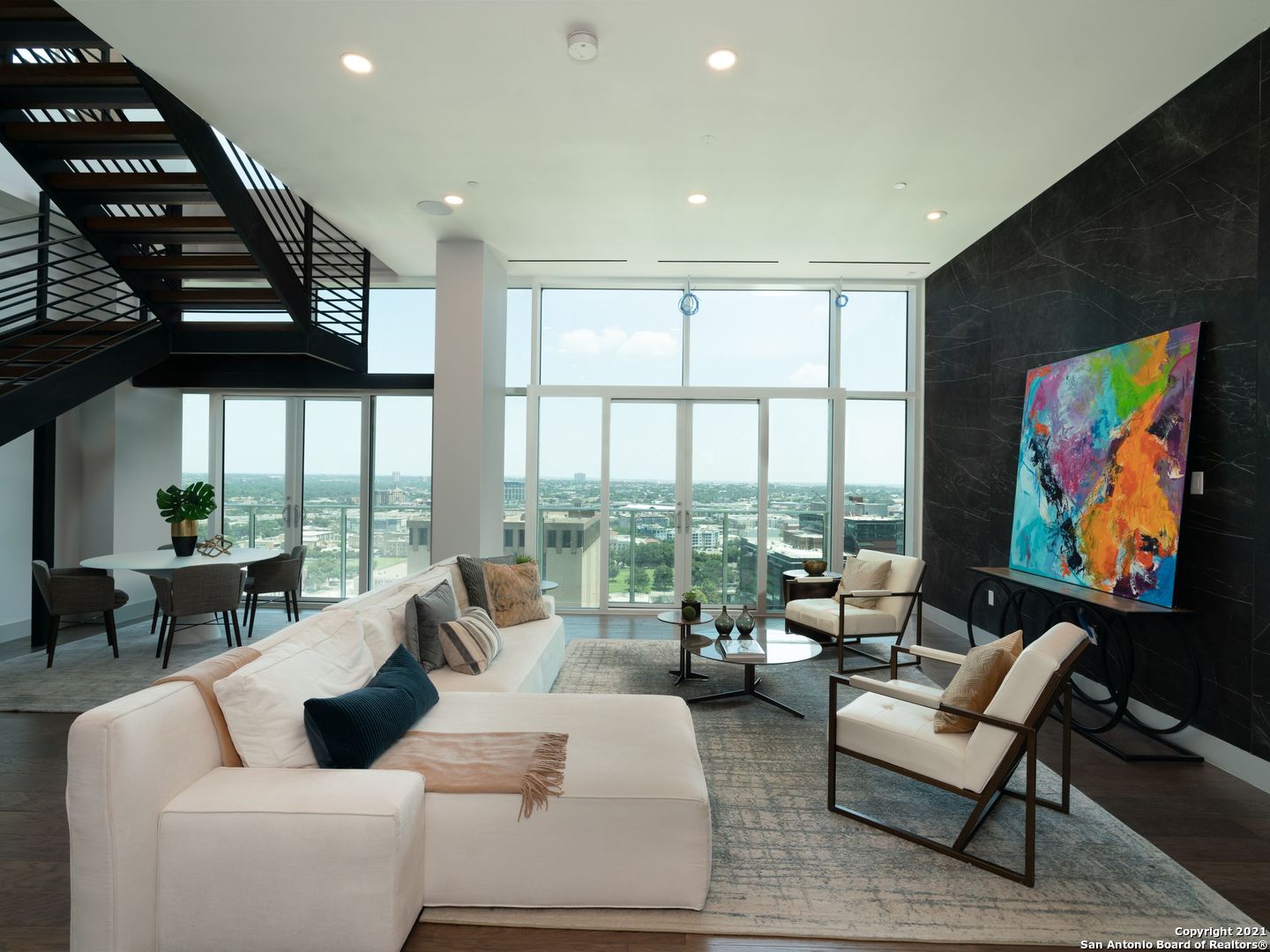 The Chopin at the Arts Residences is a two-story Penthouse with 12 ft floor-to-ceiling windows and designer finishes. This residence has an expansive living area and a wet bar for entertaining. The large walls are made to showcase art. Views to the North and South provide both tranquility and downtown energy. Located above the Thompson Hotel, amenities like 24-hour concierge, valet parking, and optional housekeeping and linen service offer a low-maintenance lifestyle. The kitchen has Gagganeau appliances, Italian Pedini cabinetry, an extended porcelain backsplash to the ceiling, a walk-in pantry, abundant cabinet space, a great island with porcelain countertops. Near the kitchen, there is a large area perfect for cooking prep, catering staff, or a great wine room. Enjoy amazing views while cooking, or take advantage of 24-hr room service from LandRace, run by James Beard Award finalist Steve McHugh of Cured. The bedrooms are located off of a long hallway that is another great opportunity for an art gallery. The primary suite has downtown views and two separate baths with heated floors, a large jacuzzi tub, a Toto toilet, and generous closets. A sitting area with sliding glass doors offers fresh air while you enjoy morning coffee or cocktails to watch the city light up. There are two spacious guest rooms, both with ensuite bathrooms and amazing closets. A study separates the two guest bedrooms and would make a great movie theater, meditation room, or cozy library. Another flex space at the end of the hallway with direct downtown views and a full bath could be used for a Peloton, art studio, or even as space for a live-in. Downstairs would make a breathtaking entryway with space for a piano, or a second living area with sliding doors that open to enjoy a cigar or fresh air. This residence comes with a private, enclosed 3-car-garage and is wired for speakers, smart home technology, and electric shades throughout. Residents have full access to the Thompson pool with cabanas, bar, and cafe. The hotel spa has a steam room and sauna and offers in-home massages. Other services available include dog walking, car detailing, personal shopping, housekeeping, linen service, and dry cleaning. While LandRace offers riverside seating downstairs, The Moon's Daughters has rooftop dining and cocktails upstairs. Located on a quiet part of the river next to The Tobin Center for the Performing Arts, residents enjoy preferred access and ticket purchases to all shows at The Tobin. Come experience The Art of Living Beautifully.