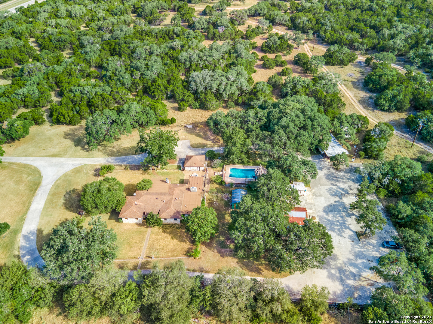 Have you ever wanted your own compound minutes from Sone Oak? Here is your chance. Private and secluded, country-like property on 2.5 acres with single story home + two detached workshops, swimming pool, green house, 1465 sq. feet mobile home and plenty of parking for RV's and boats. Property is located outside the City limits, but minutes from within Stone Oak and 1604. Main home features 3 living areas, 2 wood burning fireplaces, a huge master retreat and all surrounded by grand oak trees.