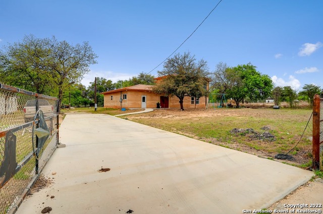 **Open House Saturday May 21st 11am-3pm**  The very first rammed earth house in Bexar County, energy efficient courtyard design and material to live a sustainable country lifestyle in 3.6 acres of land; grow your herbs and veggies, keep your chickens for eggs and enjoy the countryside in this lovely 2,800 square feet 3 beds 3.5 bathrooms and an office with balcony amazing new construction.    Walk through the antique wooden doors and walk into a lovely courtyard where you can enjoy your morning coffee and the birdsong every day. Leverage the sun and moonlight and enjoy the classic Roman Style architecture used for centuries.  Built on a solid foundation that holds the weight of a 4-story building, this rammed earth house features two boxes of 18-inch thick pest-free, fire resistant, energy-efficient rammed earthen walls that stay cool in summer and warm in winter. Metal roof and plenty of storage space in this spacious home with walk in closets and multiple doors and windows for natural lighting. This sustainable construction doesn't need an AC system; the house is cooled efficiently with mini splits in the dining and living area, and in the master bedroom. In winter, the home is warmed with a wood stove in the living and dining area, keeping the home in a comfortable temperature and spending around $100-150/month in electricity.   Work from home in the second floor office with a balcony with a view to the countryside, Enjoy the spring blossoms and watching the neighbors ride their horses on Saturday mornings in beautiful Losoya Texas, outside of city limits but part of Bexar county with city water and electricity, and a water well for the multiple water faucets throughout the property on 281 highway.  Earthen walls were built with soil from the same property. Back of the property is fenced separately where the hole still is visible and a natural pond can be easily installed. The property also includes incomplete structure that can be removed or rehabilitated for barn or other projects purposes. ]  Being on the highway in an up and coming area, minutes away from Mission del Lago Golf Course, Toyota, TJ Maxx and NuStar campus, this is prime real estate on a major highway with huge residential and commercial potential close to the Brooks City area for winning, dining and shopping.   Get homestead and farming county exceptions and enjoy the Texas country where the soil is conducive for growing fruits and veggies, keep your own animals for clean consumption and work from home in a small piece of paradise living a sustainable lifestyle. The home is ready for you to make your finishing touches.