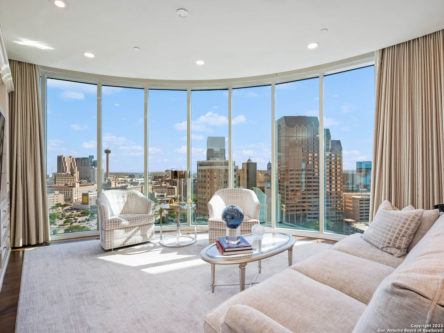 This 2,116 square foot residence has expansive living areas and stunning downtown views through a huge curved glass wall. The Picasso floor plan, the most desired in the building, features 2 bedrooms plus a study, 2.5 bathrooms, and a balcony. The main living room has an electric fireplace, custom-fit area rug, and built-in bar drawers. In the kitchen, glossy white cabinets reach the ceiling for abundant storage, with Quartz countertops and a wine fridge. The primary bathroom has a customized vanity with mirrored surround, and the closets have been neatly finished. The study is large with built-in desks and cabinetry. Extensive upgrades, like new crown molding and beautiful built-ins make this residence warm and elegant. The polished hardwood floors, trim feature walls, window treatments, and heavy brass hardware elevate the space, and the owner has added custom light fixtures and electric shades. Located above the Thompson Hotel, amenities like 24-hour concierge, valet parking, and optional housekeeping and linen service offer a low-maintenance lifestyle. Residents have full access to the Thompson pool with cabanas, bar, and cafe. The hotel spa has a steam room and sauna and offers in-home massages. Other services available include dog walking, car detailing, personal shopping, housekeeping, linen service, and dry cleaning. While LandRace offers riverside seating downstairs, The Moon's Daughters has rooftop dining and cocktails upstairs. Located on a quiet part of the river next to The Tobin Center for the Performing Arts, residents enjoy preferred access and ticket purchases to all shows at The Tobin. Come experience The Art of Living Beautifully.