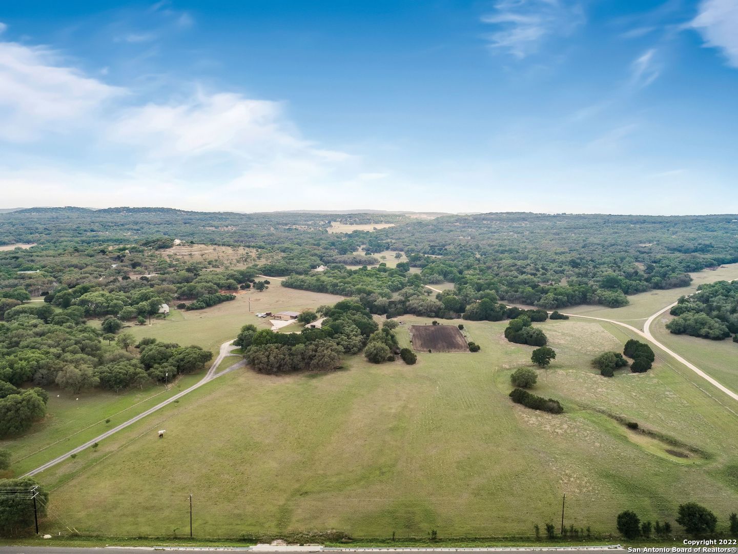 22.579 +/- ag exempt acres. 4 miles east from the quaint town of Boerne. Hill Country rock home surrounded by a canopy of live oak trees. Heated pool w/hot tub, 25 x 34 covered back porch, barn with 36 x 13 apt., 6 stalls/runs, tack and work room area, wire fence arena 150 x 250 w/return alley (black dirt), 2021 Barndominium 1,764 sq ft 2 bed, 2 bath with urban interior w/carport 42 x 12. The main home has wide open spaces, limestone wet bar, nice size bedrooms, wood burning fireplace and a double sided heatilator in the master bedroom/bath, separate office space and exterior entry. A great family compound. No commercial. Buyers should be pre-qualified.