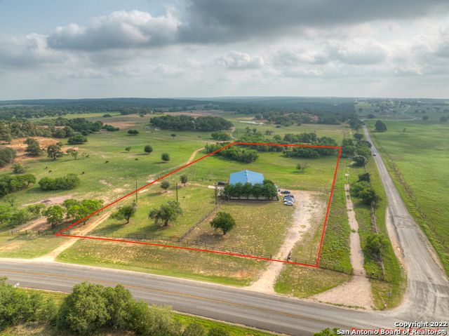 The property located at 13440 FM 539, LaVernia, Texas is a great opportunity for a wide variety of uses. This 5.96 acres is not located in an incorporated area (city limits), which means there is no zoning in place for this property. The large metal building totals 6,028 square feet with two large roll up doors. Out of the total square footage, there is a 2254 sqft space finished out for either office space use with a commercial grade kitchen; or as a residential living area with bedrooms and full bathrooms. Servicing the property are two large septic tanks (1250 & 1000 gallon), two grease traps, a 12.5 ton AC system with a 15 ton air handler, 3 Phase electricity. The acreage is encompassed with good solid pipe fencing. This property would be great for an events venue. Or it would be great location for many types of service businesses who need a shop for equipment and vehicles and plenty of yard space to boot. The living area makes it very convenient to be located near your business and assets. There two additional ADA bathrooms that have roughed in plumbing that are ready to be finished out. A portion of land is Ag Exempt.