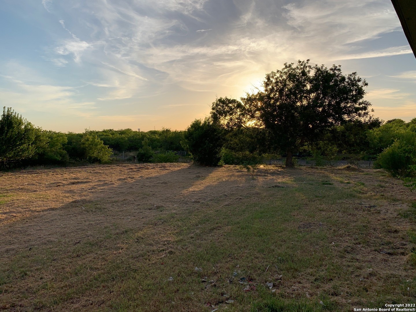 Enjoy the sunrises and sunsets out on the porch or in the yard!!!! This ranch style home sits on just over 11 acres outside the city limits of New Braunfels. This property also features long creek running thru the property on the left side facing the house by the tree line, a very large pond and approximately 650 feet of FM725 Road frontage. Potential for some commercial.