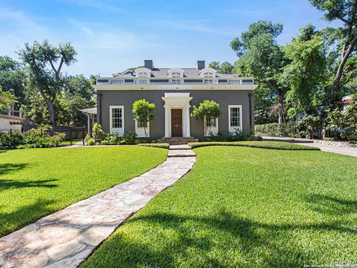 This striking home garners the most elegant and memorable curb appeal on one of the best-treelined streets in Olmos Park! The property has been meticulously and lovingly updated throughout the years to blend the grace of the original 1928 home with today's luxuries. The entrance is sophisticated yet approachable with the original solid wood door welcoming guests, a gentle curving staircase with custom wrought iron railing, updated sconces, and the original wood parquet floors which flow seamlessly into the formal dining and living rooms. The spacious formal living room becomes draped in soft natural light during the day and boasts the 1928 stone fireplace. The dining room has pocket doors that can be opened for casual entertaining into the epicurean kitchen or closed for more intimate dinner parties. The circular layout of the downstairs is perfect for entertaining and hosting large parties as the kitchen flows into the breakfast banquet, with an architectural coved ceiling the is featured throughout the home, and continues into the large family room. Serval patio doors lead to either the 350 sqft screened-in porch for lounging and watching the game year round or to the inviting flagstone patio with built-in seating and an outdoor kitchen with a gas range and green egg. There is a wine bar/butler's pantry, washer/dryer, and half bath on the first level for convince as well. There are two staircases to access the 2nd level, continuing the easy flow up to the 3 guest bedrooms with 2 bathrooms, perfect for guests or little ones. The primary suite is an absolute stunner! Recently updated, the coved ceiling in the bedroom creates a relaxing and calming environment coupled with light-filled patio doors that open onto a screened-in porch with gorgeous custom tile for morning coffee or evening wine. The bathroom is one to remember with exquisite tile flooring, multiple vanities with honed Carrera marble counters, a generous walk-in shower, custom brass fixtures and lights, a coffee bar, and second Bosch washer & dryer. No expense spared for luxury and convenience! Please do not miss the 630 sqft casita with living room which could easily be used as a large home office, a bedroom, and full bathroom for guests. 114 Park Hill is truly a special and unique home in the best location that is ready for the next stewards to continue the love and adoration all owners have experienced while living in this stately masterpiece.