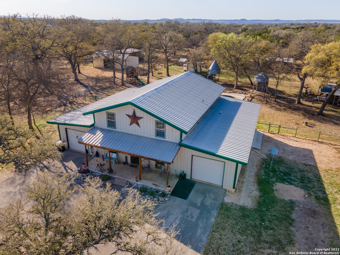 Texas Hill Country Gem! THE LAND is easily accessible and less than a half mile from State Highway 173 between Kerrville (15 minute commute) and Bandera (3 minute commute). An electric, gated entrance will grant you access into the Wildlife Tax Exempt, 21 acre property that boasts mature hardwoods, level land, and good soils. THE IMPROVEMENTS include a 3bdrm 2 bath 2461 sq ft home, w/ an in ground pool, a workshop most men only dream of having, horse barn w/ 3 stalls, tack room, water and electricity, additional loafing shed with 3 stalls and a hay shed. THE HOME is an all metal construction with 6" spray foam insulation to beat the heat! Fiber Optic Internet connection, stained concrete flooring on the main level, custom cypress cabinetry in the kitchen, with granite countertops and island in the kitchen. Upstairs is a loft with a 3rd bedroom and additional living room area. There is an additional interior electric gate that opens to a circle drive when you drive up to the house. One acre of land is fenced around the home for pets. The in ground pool/spa was installed in 2021 - it is remote operated, heated and 7 feet deep. THE SHOP has 3 bays with a vehicle lift in the center. Over 70 yards of concrete used in the construction of the slab with 2'X2' footers/beams around the perimeter and below the lift. There is also an office and bathroom in the corner of the shop. Additional vehicle storage includes; 2 attached single car garages, a motorcycle storage with a roll up door, and an ATV/mower storage off the side of the home. This property WILL NOT LAST LONG... Call and schedule your showing ASAP!