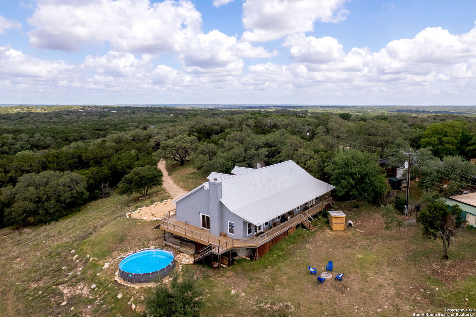 If breath taking views and hill country living are what your heart desires, here it is! Just under 10 acres, UNRESTRICTED (can be used as a short-term rental) close to New Braunfels and Canyon Lake. 6 bedrooms, 4 baths and a game room, offers tons of space for family fun! Home has had many updates including the following - metal roof, newly painted exterior and new well pump, all new pipe inside existing casing, replaced wiring and pressure switch on the pressure tank.