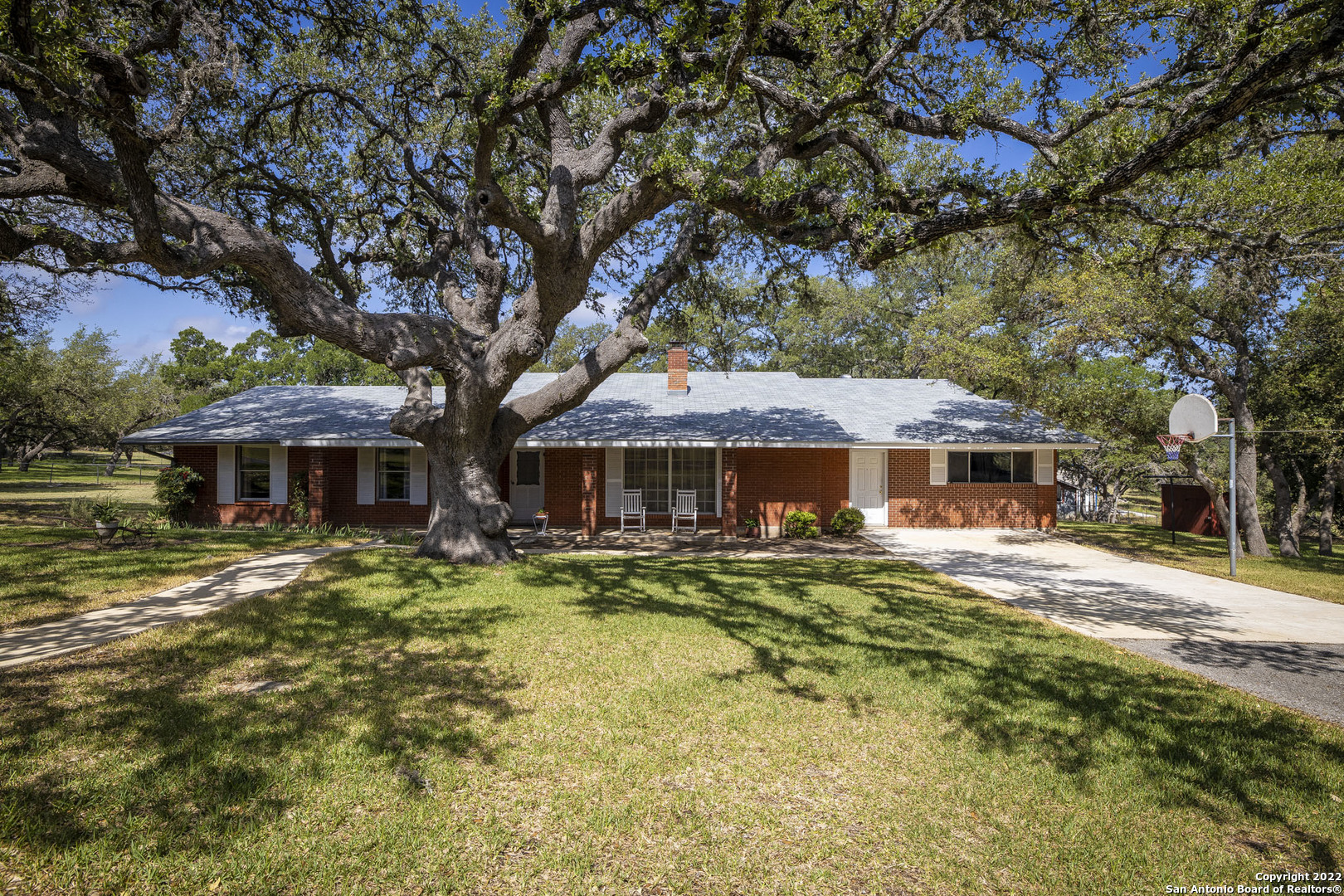 ***OPEN HOUSE 8/7 2-4PM*** As you pull up to this Hill Country Home, you are greeted with a massive Oak tree that is soaring into the sky with lovely climbing limbs and rich history! On almost 3 acres, this home allows for endless opportunities; 4H/FFA projects, stalls, tack area, 3+ car carport, circle drive, mature & wooded trees with woods to explore & so much more! You are RIGHT in the middle of it all, located right next to Timberwood Park, off Borgfeld Rd, close to the BRAND NEW PIEPER HS, grocery stores, shopping, etc & no HOA! Bring your boats, RVs, trailers, & have a ball! As you enter the exceptionally maintained home, you are greeted with over 3,000 sq feet of entertaining space. Two living areas, 2 dining areas, dual masters & a fireplace that is magazine worthy! The kitchen features a window out to view your property with custom cabinets, island kitchen and an open floorplan that allows for a functional flow & great space for your family! The back porch is covered and elevated for a fantastic breeze for all of your Texas sunsets. Step off the porch to lovely trees, mature landscaping & opportunities to make this space your own! This is a Texas dream come true!!
