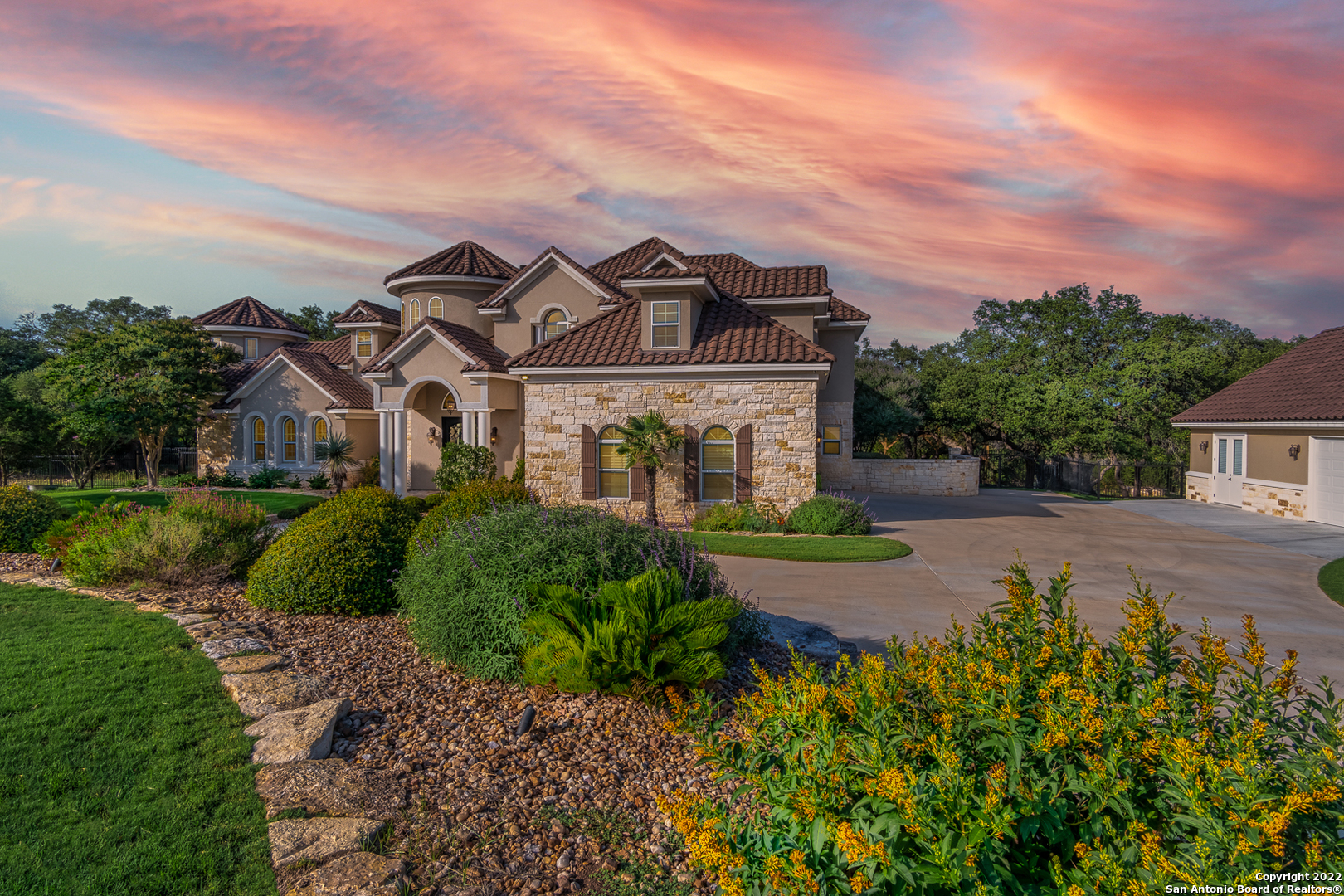 **OPEN HOUSES:  Friday, June 17, 4-7 pm and Saturday, June 18, 11 am - 2 pm**. A stunning one-of-a-kind home located in one of the most highly sought after luxury neighborhoods in the Texas Hill Country. This 6,354 square feet of pure perfection sits on over 3 fenced acres & boasts of 5 spacious bedrooms, 6 bathrooms, media room with 4K technology, TWO wi-fi enabled heated swimming pools, a diving board, a waterslide, water features, grotto, 320 foot long zipline, treehouse, outdoor kitchen, three car garage and an additional two car garage with attached gym and so much more!  Surrounded by majestic oaks, the property also backs to Hill Country views with no rear neighbors - privacy abounds!  The main house is a 5,204 square foot open floorplan and is an entertainer's dream!  Walk through the front doors into a grand entryway with a sweeping staircase that opens to a large family room with a 25 foot tall limestone wood burning fireplace.   Gorgeous hardwood & tile floors throughout as well as luxurious carpet in the bedrooms.  The massive master bedroom, overlooking the resort style backyard, has its own coffee/wine bar, a 265 square foot closet, walk-in vault, huge shower and tub for two!  The kitchen is filled with wall-to-wall custom cabinets, granite counters, 6 burner gas cooktop and two islands!  A media room sits just down the hall and has 7 comfortable reclining chairs perfect for curling up to watch your favorite movies on a 4K screen!  Upstairs are 4 additional bedrooms, all with access to their own bathrooms & large walk-in closets.  The secondary building has a two car garage and an attached 500 square foot air-conditioned gym with commercial grade PreCor exercise equipment (that may be included if buyer is interested) and a 650 square foot air-conditioned bonus room upstairs!  Located in Vintage Oaks, you'll have access to world class amenities:  lazy river, 4 swimming pools, park, playground, 6 miles of trails, fitness center and more.  This home & community are the definition of 'resort style living at its finest'!
