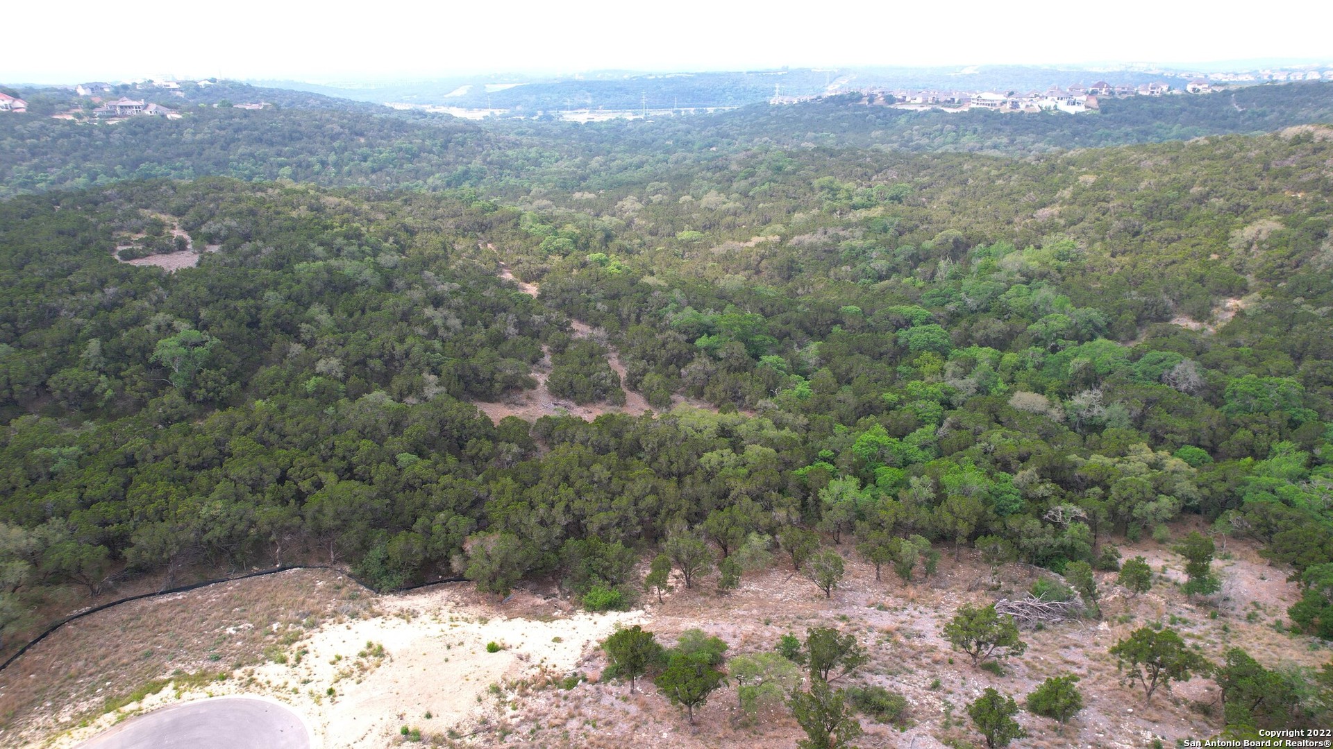 Rare opportunity. 5 acres! Build your dream home in the beautiful hill country with a valley breeze. Located on a cul-de-sac. Established neighborhood. Controlled access. North and West bordered by 7.4 Ares tree conservation. 80 acres Crown Ridge Park to the South. Valley views of parkland. Complete Privacy of 20 + acres with surroundings!! Follow green stakes to proposed building site with view. property line is roughly 40 ft past the old ranch fence. It is marked by several orange ribbons on tree limbs. Close to I10, shopping, restaurants, entertainment, 20 minutes from downtown San Antonio. Buyer to verify taxes, lot dimensions, school districts.