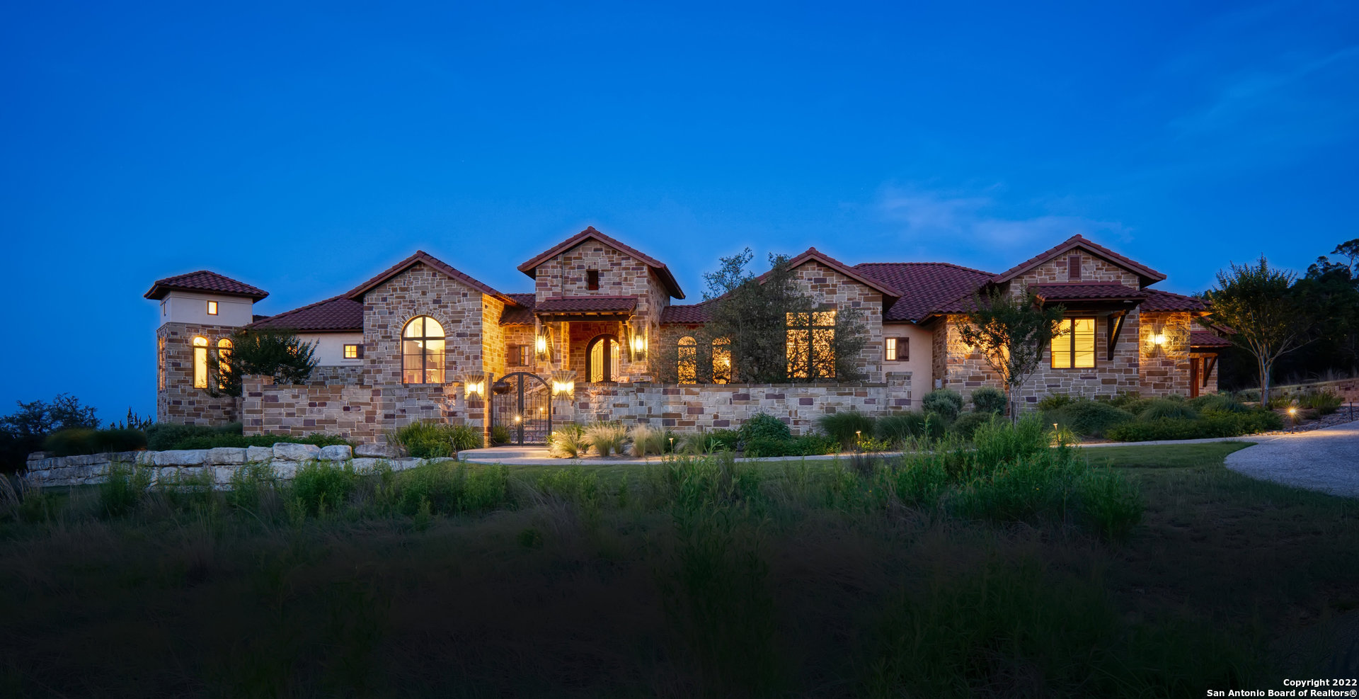 What an opportunity awaits you with this exquisite, stunning custom home with Hill Country sweeping and long range views AND privacy on the very rare 2.07 acres within "The Clubs Area" of Prestigious Cordillera Ranch just a short golf cart ride to the course and club.  Arriving at your majestic front entrance  and though to the foyer your eyes  are drawn out to the views and then in two directions of the gallery accented by custom sconces and chandliers to see stone accented Art niches leading you to thoughtfully well planned out areas of living spaces with an incredible amount of detailed careful planning and execution. The formal generous dining room with an accent wall of warm stone is adjacent to the wine room and the butler's pantry. The kitchen, the nook and the captivating living room all look out to the views and spectacular outside living areas. The entertainer enthusiast has their dreams come true with this gourmet kitchen with a huge island, breakfast bar, an abundance of custom cabinetry and storage. Wolfe appliances and the gleaming copper vent hood surrounds many work spaces and a walk in pantry. The kitchen opens to a very generous dining nook area and as well, opens to the impressive great room featuring the stoned floor to ceiling fireplace. The perfect place to relax and entertain and embrace family time is the amazing outdoor living spaces. A wrap around patio with many sitting and  dining options looks out to the beach entry pool, waterfall and infinity edge spillway. A summer kitchen is located on the expansive covered patio with fireplace and another sitting  area. The well executed outdoor living spaces cohesively blend flagstone areas, planting areas and natural vegetation. All of this is surrounded by the unsurpassed scenic views of the Hill Country. This home boasts 4 bedroom suites, two offices perfect for remote learning and work, a media room, and another living room between two of the guest suites. An impecable oversized three car garage abundant with storage is close to the separate fourth car air conditioned oversize garage.  The master suite is the epitimy of what a master suite should be. Its own wing of the home with a private wrap around patio offering fabulous views. Refined elegance best describes the dramatic bedroom and bathroom with the freestanding tub framed by windows and views, the two onyx vanities, coffee/wine bar and a marvelous built in closet.  This home is very special and exudes warmth and great taste. call for your private viewing.
