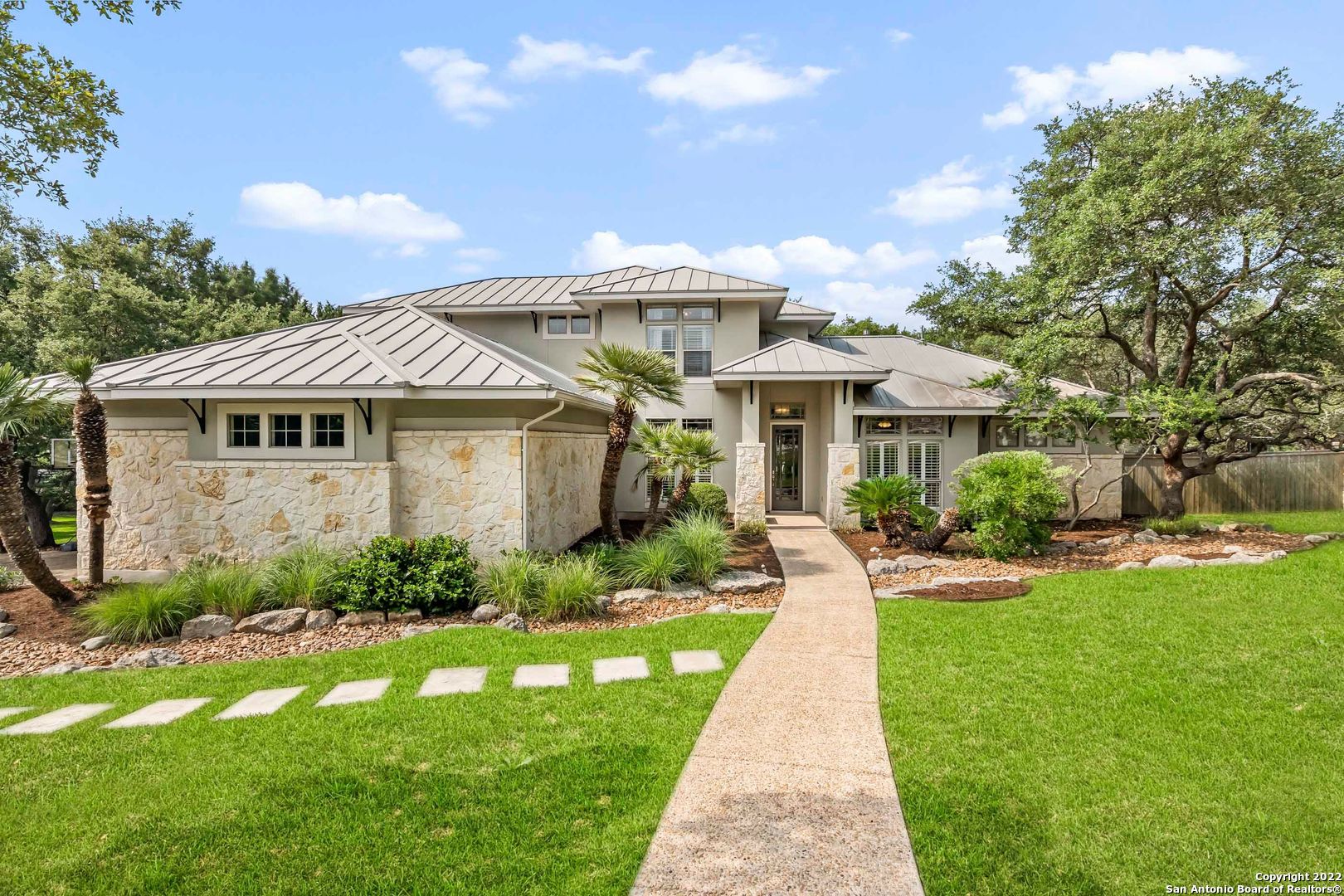 This luxury home perfectly marries gorgeous design elements with a fantastic location. Tucked away on a large lot in Village Green with plentiful oak trees, owners will enjoy access to highly rated Boerne schools with all of the conveniences of San Antonio just a short drive away. Guests are immediately welcomed by this home's timeless curb appeal and lush landscaping. Inside, high-end details include vaulted ceilings, custom crown molding, hardwood and tile floors, plus limestone accents. Acting as the heart of this home is a beautifully updated kitchen which flows seamlessly into the warm and inviting family room. This culinary arena provides natural stone counters, subway tile backsplash, white cabinetry, gas cooktop, and an expansive island. Completing the first floor is a private study, formal and casual dining areas, plus a luxe owner's suite with private bath, tray ceiling, and patio access. Upstairs are three nicely sized secondary bedrooms and two full baths centered around a loft-style game room. This listing also boasts a three-car garage and fantastic back yard that features a sprawling covered patio, multi-level deck, fire pit, playscape, and refreshing pool.