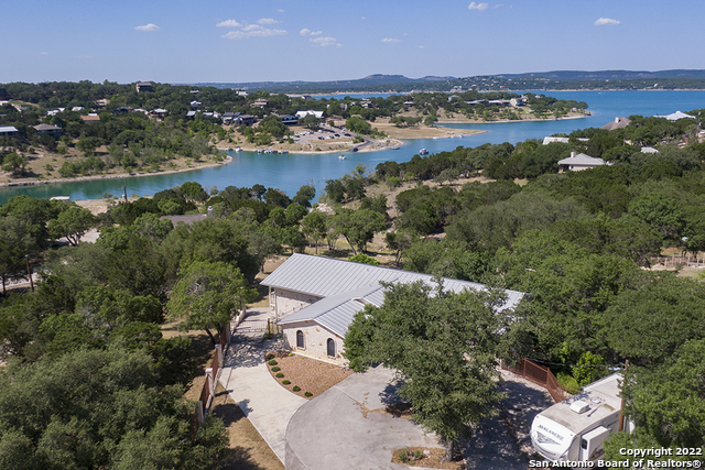 CANYON LAKE WATERFRONT! Rare to find this much land & home with lake access. The home is 4 bedrooms, 2.5 baths plus, workout room. Master bedroom & bath, kitchen, living & dining are all on the main floor which was remodeled in 2017. You will love the large chef's kitchen, dreamy master bath & private access to the deck from master bedroom. Downstairs has 3 bedrooms & bath which is the perfect space for guests. The home is focused around lake & hill country views. Bring your RV, boat(s) and golf cart...there's plenty of room at the front of the property including RV parking w/water and electric. Easy pathway & steps to the water to go for a swim, kayaking, SUP or hop on a jet ski. Turkey Cove boat ramp is directly across from the property so, easy to launch your boat and park at the cove.