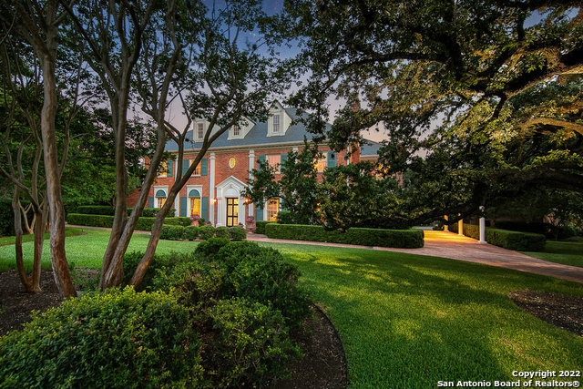 This is a modern classic, tucked behind lush landscaping on an acre in The Dominion. Are you tired of the generic contemporary aesthetic of stucco, white, gray and black metal? Ready to enjoy an exquisite estate that stands the test of time? Nestled on a fantastic corner lot, this traditional home has all of the timeless details that classic architecture enthusiasts may desire.    Stunning exterior features are sure to impress - from the Georgian colonial architecture to the all-brick masonry, slate roof, wrought-iron fencing, large circular drive, covered breezeway, expansive balconies, and thoughtful landscaping. The main house offers nearly 7,000 sq. ft. of living space with bespoke finishes like herringbone-patterned hardwood floors, quilted grasscloth wallpaper, and supple marbles. Traditional elegance abounds. The grand foyer welcomes guests past a spiral staircase with custom chandelier. Within each formal and casual living area, enjoy custom crown molding, artful entryways, one-of-a-kind crystal chandeliers, and carefully designed display lighting designed to showcase your art collection. This floor plan was certainly designed with exquisite entertaining in mind, easy to picture within the formal dining room showcasing seagrass wallpaper and beautiful fireplace or the rich family room with marble-topped wet bar, exquisite millwork, fireplace, plus dual French doors overlooking the back yard. The more formal living and sitting rooms also feature outdoor access and provide intimate spaces to gather. With too many hidden treasures to mention, this home also includes a sunny island kitchen with large casual dining area, an expansive owner's suite with spa bath plus dual closets, and a well-appointed home theatre.    Additionally, the property offers a lovely, 979 sq. ft. one bedroom, one bath guest apartment above the four-car garage. The grounds are simply spectacular. With a gorgeous Keith Zars-built pool & spa, large covered outdoor living spaces, spacious lawns and an English garden, it's rare to find a setting like this.