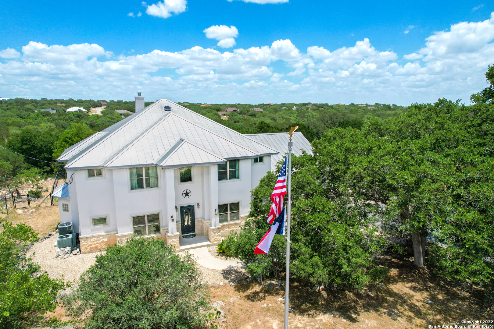 Tucked away on this large 1 acre lot sits this 3877 sqft custom-built, Brad Moore home, that backs up to Devil's Hollow Nature Preserve located in the highly sought out community of Mystic Shores in the TX Hill Country. Open floor plan, soaring high ceilings where the entryway gives way to the formal dining on the right and the study on the left--both rooms with elegant trey ceilings.  Enter into the large living area with a cozy wood burning, floor to ceiling fireplace, and large windows provide lots of natural light. New metal roof, all windows replaced in 2017 and new upgraded custom steel doors with Texas star accent in the front and back. Kitchen has built-in oven & 2 microwaves, smooth-top cooktop, granite counters, under mount sink, glass-front cabinetry, and center island for additional workspace. Master bedroom has extra insulation on the shared wall with the living room. Light pours through the master bath with numerous windows, walk-through shower, and a large garden soaking tub. Family room/loft upstairs with wet bar & mini fridge, 4 secondary bedrooms and 2 bathrooms. Covered balcony with breath-taking hill country views accessed from a bedroom upstairs. Expansive game room with screen & projector. Enjoy the serene Texas hill country landscape on the outdoor patio. Small shed for additional storage. The home is also plumbed for propane, but no tank. With access to Mystic Shores amenities, such as lake access, boat ramp & dock, RV storage, tennis courts, basketball courts, volleyball court, swimming pool, pavilions, 233 High Point's value extends beyond the private 1 acre lot. Come make Mystic Shores home! (For a Matterport 3-D tour contact the listing agent!)