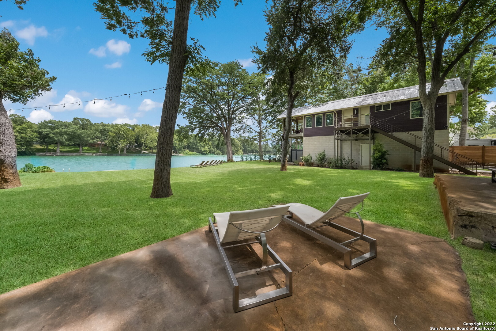 An entertainers dream and short-term rental friendly! Stunning custom home with 108' of Meadow Lake waterfrontage. Lakeside the 100' retaining wall/bulkhead has a sidewalk and aluminum dock ladder for easy access in and out of the water. Use the nearby neighborhood boat ramp and spend the day making sweet summertime memories and enjoying the great outdoors! Wash off in the private outdoor shower. Perimeter fencing and two 10' electric gates with a keypad at the property entry provide privacy and security and guests can conveniently enter the property through the pedestrian gate. The lawn is spacious, and the full-yard sprinkler system makes maintaining the beautiful green grass easy! Mature trees provide shade and special yard lighting creates a charming ambiance for lakeside dinners hosted on the oversized uncovered patio. Play your favorite dinner playlist through the built-in (inside/outside) sound system and use the wet bar to serve your guests! There are two covered patios - one upstairs and one down. Inside has the look and feel of a boutique-hotel with modern amenities, high-end fixtures, and a thoughtful design that takes every square foot into consideration. Feel the lake breeze with the specialty Low-E casement windows while you prepare dinner in the gorgeous kitchen! Fully equipped with all stainless-steel appliances like the Bosch chimney style hood and the built-in drawer style dishwasher and refrigerator. The stylish tempered-glass bar and specialty Spanish Porcelanosa tile feature wall are highlighted with the halogen recessed lights and tons of natural sunlight! The spa-like bathroom features an all-tile shower with a rain shower head and a Restoration Hardware vanity and medicine cabinet. The AC and wi-fi thermostat were installed in 2022 and the septic is large enough to accommodate four bathrooms and two kitchens. The oversized garage will fit a mid-size boat or RV and there is closed foam cell insulation under the house. No city taxes and the HOA is voluntary! Must see!