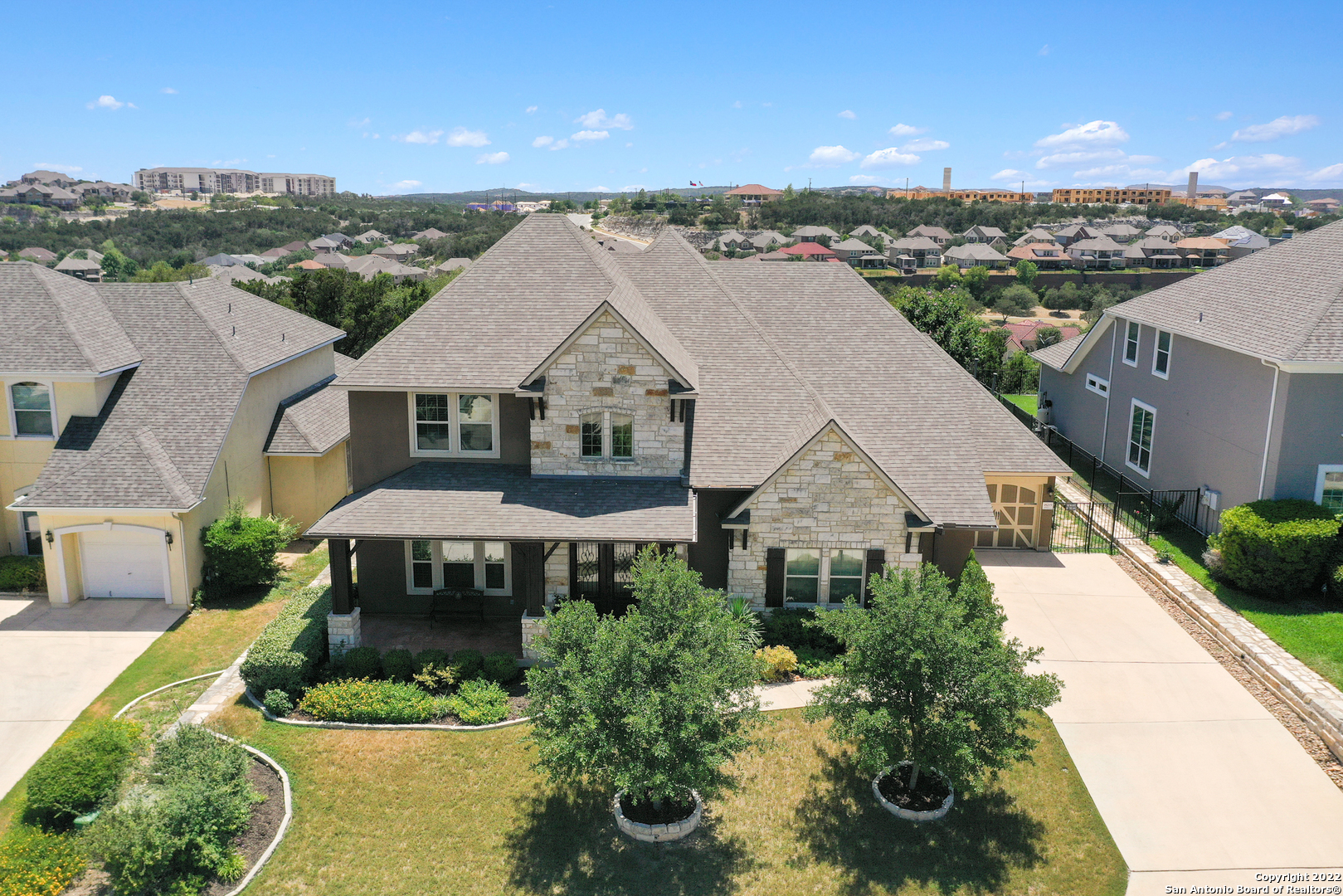 This majestic property is situated on .25 acres and offers stunning interior finishes adding to the home's unique and sophisticated feel. You will have quick and easy access to 1-10 & loop 1604 with close proximity to La Cantera, The Rim, UTSA, USAA, Medical Center, and multiple upscale golf courses! Upon arrival, gorgeous curb appeal is evident through the meticulously maintained lawn, delicate landscaping, light stone with contrasting stucco, and stylish structure. Inside, a grand foyer greets you with soaring ceilings and views of the detailed wrought iron staircases. Rich hardwood floors guide guests to the formal living space with an ornate chandelier and natural lighting. In the common areas, picture windows are highlighted by stone accents, a spacious living room with surround sound, and a warm fireplace. The household gourmet chef will revel in the top-of-the-line GE Monogram appliances, including the GE Elite Pro water filtration system. Stylish yet functional selections include all-white cabinetry, complementing counters, a stylish backsplash, a custom granite island with bar seating, and an eat-in kitchen. Dedicated office space is also located on the main leave with French doors for privacy. Retreat to the luxurious-sized primary offering tray ceilings, bay windows, and room for a seating area. The en suite offers granite counters, a spa-like soaking tub, a roomy walk-in shower, and travertine tile. A generous game room can be found upstairs for additional entertaining. The media room is also pre-wired for surround sound. Outside, a stained patio with a built-in kitchen also features GE monogram appliances. In addition to all this home has to offer, plenty of green features include attic insulation, double pane windows, enhanced air filtration, and much more. Peace and tranquility are evident with views of the greenbelt and Texas sunsets. **Pool table and living room TV convey with the property**