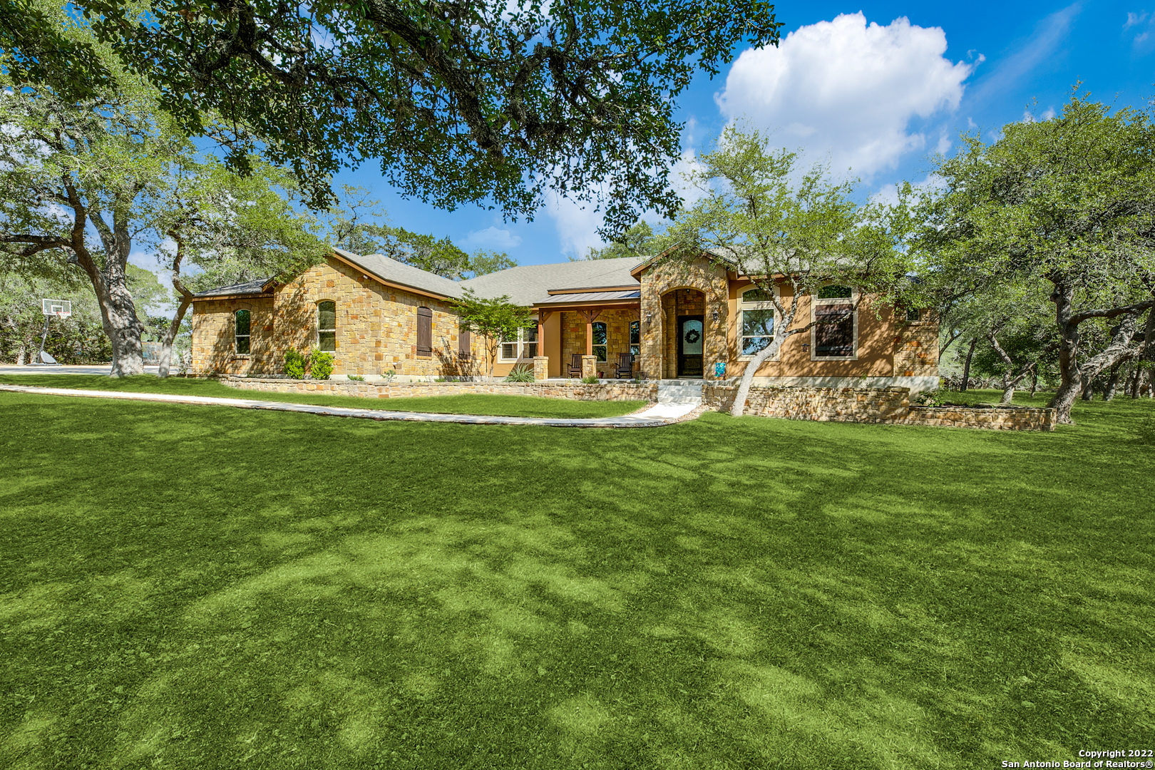 Welcome to 578 Prado Crossing located in the beautiful Spring Creek Estates. Located only five minutes outside Boerne, this home is in a highly sought-out location. A lengthy drive from the curb offers views of the shaded home on the approach. Warm colored stone and stucco make up the beautiful main exterior. A spacious front porch is framed by stone landscaping and wooden columns-the perfect place for enjoying your morning coffee. Inside, enjoy the space provided by an oversized layout, gleaming stained concrete floors, and natural light pouring in from all angles. A home office near the entry is perfect for those working from home. The open-concept dining room is fit for a large table set under a tiered tray ceiling and chandelier. A formal sitting room nearby offers picturesque views of the back yard through towering windows. The kitchen comes equipped with plenty of storage space behind custom oversized cabinetry, stainless-steel appliances, granite counters, glass cooktop island, and a Texas-sized walk-in pantry. The living room showcases both ideal views of the property outside and a massive corner fireplace made of stone to match the exterior. The primary suite is spacious and provides outdoor access and space for an additional sitting area if desired. The en suite features a dual vanity, soaking tub, and spa-like walk-in shower. Three additional bedrooms provide space for everyone or the versatility to include a home gym or additional study. All back yard access leads to an accommodating covered porch with steps leading to an extended patio-the ideal setting for your next outdoor gathering.