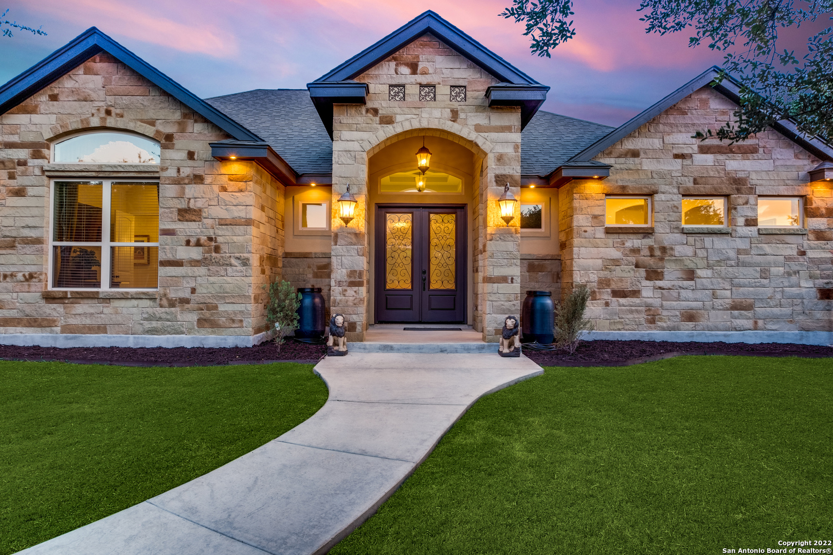This marvelous, single-story home is situated on a generous-sized lot accessed by a private gated entrance. Upon arrival, a dedicated driveway is surrounded by mature shade trees and a well-manicured lawn. The stone and stucco exterior adds to the home's unique charm. Inside, neutral tile flooring is highlighted by elevated ceilings, picture windows, and more. Off the entry, a dedicated office space can be found, perfect for privacy. In the common areas, an open floor plan offers to entertain at ease. The living space showcases a built-in, wood-crafted entertainment center, perfect for movie nights, and provides stylish storage. Tray ceilings and views of the tree-shaded backyard complete this area. Flowing into the gourmet kitchen, the household chef will appreciate the espresso-colored cabinetry, contrasting granite counters, stainless steel appliances, stylish backsplash, and custom island with seating. Enjoy elegant dining in the grand living space with ample room for a bar or china cabinet. Retreat to the luxurious-sized primary suite with private access to the outdoors. The en suite offers dual sinks, a sit-down vanity, jetted tub, and a walk-in shower. Two secondary bedrooms and a full bath complete the interior. Outside, enjoy al fresco dining with a fireplace overlooking the extensive backyard, perfect for making this an oasis of your own. With proximity to Blanco Road, 281, eateries, and more, come view this stunning home today.