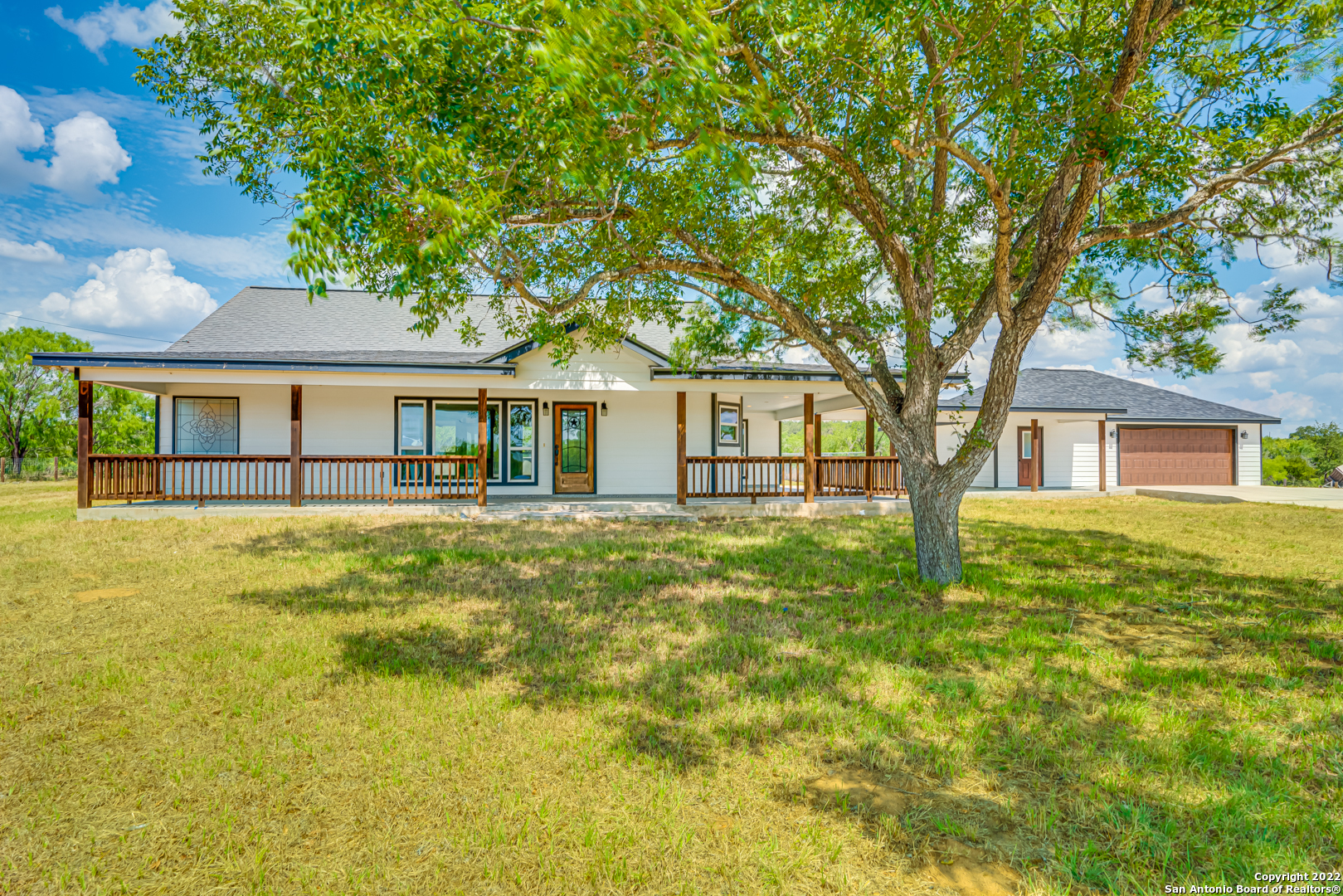 From the moment you pull into the driveway, it's immediately clear you just found a special piece of Texas. Perfectly positioned on an expansive 18 acres, the lucky new owners will enjoy room to move and play along with the potential to add some of their own personal touches without restrictions. The well-designed layout offers a split floorplan boasting four bedrooms and two and a half bathrooms with beautiful flooring throughout. For those who love to cook, the well-appointed kitchen will be a dream with granite countertops and ample storage.  An abundance of natural light enhances the sense of space plus you can bask in the stunning sunsets each day from the western-facing wrap around porch. Relish the peace and privacy of a country lifestyle while enjoying the perks of living in the highly sought-after La Vernia school district.