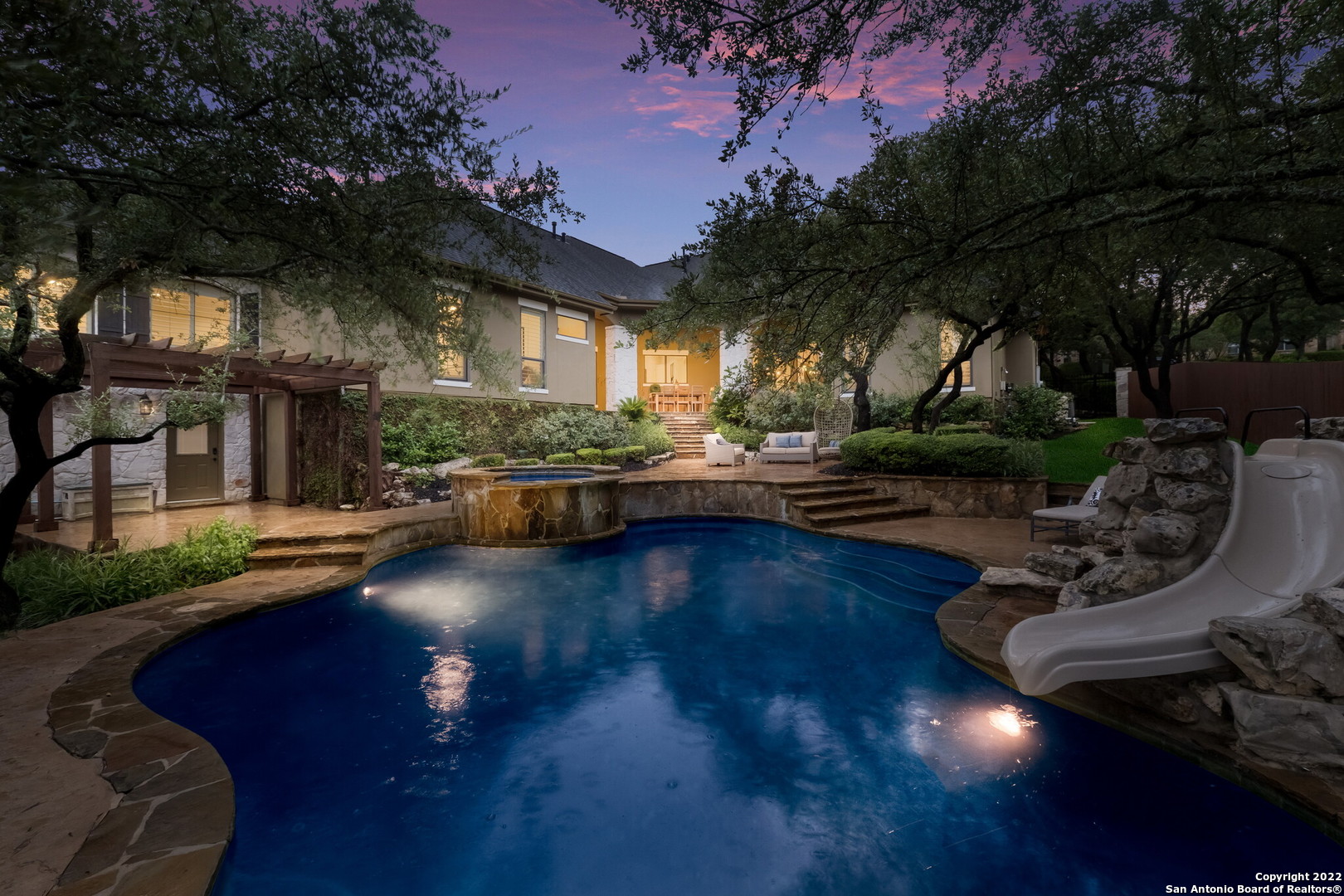 FALL IN LOVE with this beautifully remodeled one-story home in the exclusive guarded community of Summerglen. The quality and craftsmanship of the home are unparalleled as this was the former personal home of a renowned San Antonio custom home builder. The brilliant floor plan and timeless design provide the perfect balance of luxury, functionality, and entertainment. The versatile layout features a dining room, bonus room/work area, generous game room, and all ensuite bedrooms. The foyer resembles a luxury hotel with an impressive iron door, flawless design, tin barrel ceiling, & large picture windows to the backyard. The extraordinary kitchen features Thermador and Viking appliances, beverage drawers, a coveted nugget ice machine, a built-in refrigerator, custom cabinetry & quartz countertops. The gorgeous family room exudes elegance and simplicity without sacrificing comfort. The luxurious primary suite is breathtaking.  The luxe bathroom displays a grand chandelier, stone accent wall, soaking tub, coffee bar area, oversized shower, and a remarkable custom closet designed by California Closets. In addition to the kitchen, family room, garage, and all the bathrooms, the remodel included new wood flooring, new countertops, new light fixtures, new plumbing fixtures, replaced two AC units, new electrical outlets, a new full house generator, new water softener & so much more. Enjoy the park-like backyard retreat with a heated pool with waterslide & spa, multiple entertaining spaces, mosquito mister system, a sports court, an outdoor kitchen, and an outdoor fire pit. The four-car garage with epoxy flooring features two Tesla chargers, and tons of storage and it will hold all your toys including a boat & RV. Simply breathtaking.