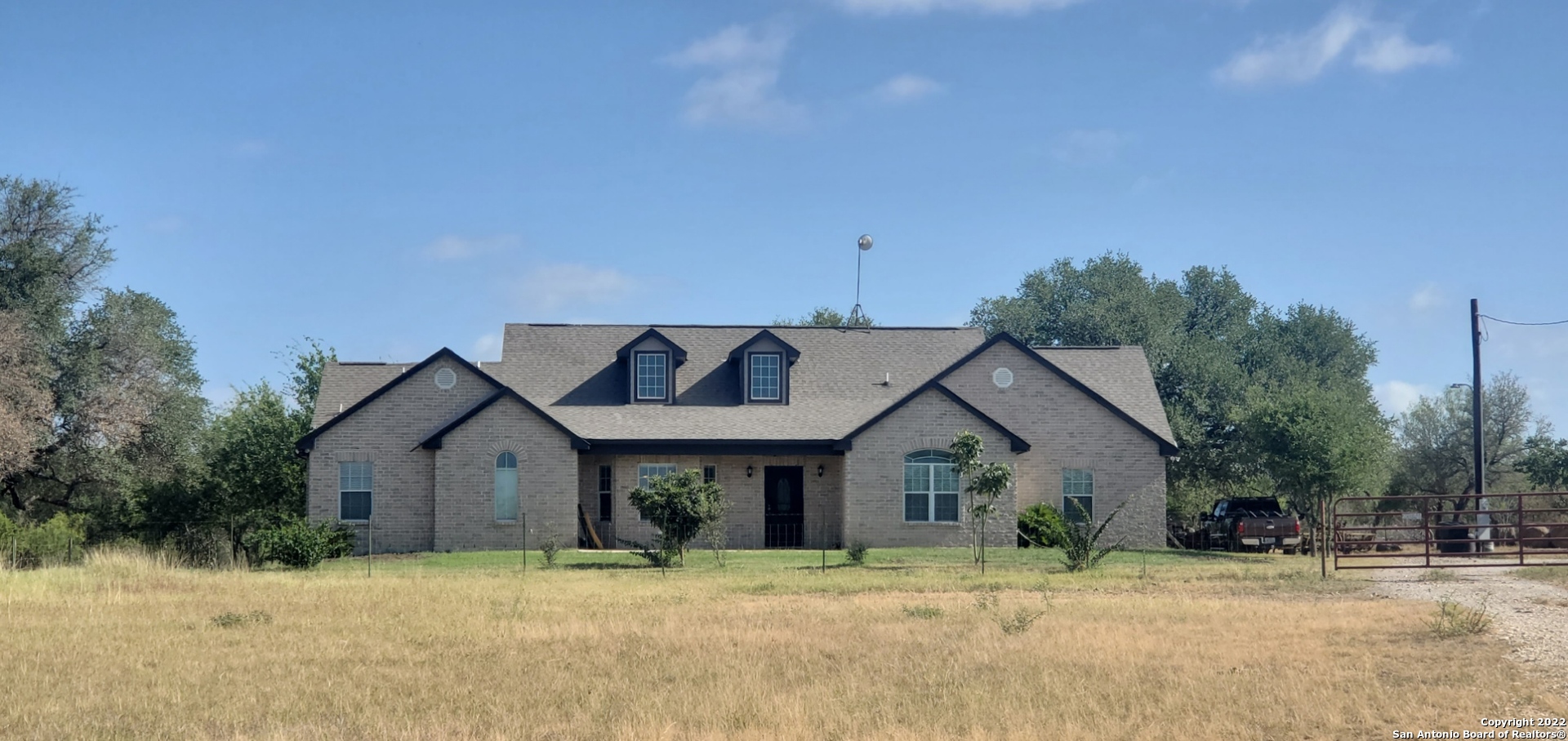 This is a beautiful, spacious 3 bedroom, 3 full bath home on 20 acres.  The home is located between Hondo and Castroville on Private Road 568, about 25 minutes from San Antonio. Entering, you are greeted with the dramatic living area of the home.  The 16' cathedral ceiling adds to this open concept.  The kitchen is separated from the living room with a wide, sit-down bar which is made for entertaining.  The kitchen is the real "Heart of the Home" - it has large counter tops and many cabinets - room for everything here.   The large pantry and separate laundry area are conveniently located in the kitchen.   The dining room is next to the kitchen. Your dining table and china cabinet will fit with room to spare.  The Master bedroom is huge and very inviting with plenty of room for dressers, couches and big beds.  The Master bath has a separate garden tub, a beautiful walk-in shower and a private toilet area.  The guest bedroom also has its own full bathroom.  The 3rd bedroom is right next to the normal guest bathroom. The large back porch/patio makes it easy to enjoy your property.  There is a large storage building which gives you a good place to store lawn care equipment, etc.  The 20 acres surrounding the home has been planted to improved grasses for hay baling or grazing.  There is a good metal barn, large enough for you tractor and other ranching equipment.  The 19 acres are appraised as Agricultural Property for tax purposes.  The entire acreage is well-fenced with some cross fencing.