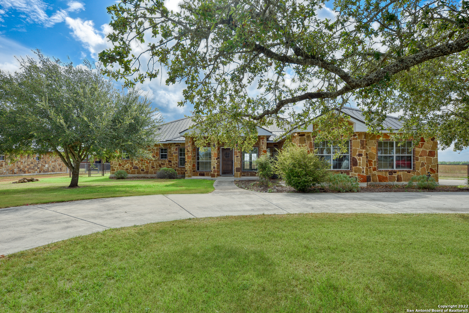 Fall in love with this CHARMING custom home on just under one acre! Minutes away from Seguin, this beautiful home fits any lifestyle as it offers a rural setting, but still within a short drive from all the amenities of the surrounding areas. The home boast a split floor plan with 3 oversized bedrooms and 2 bathrooms. Cook and entertain in your elegant, chef inspired kitchen with an expansive granite bar top and custom movable island with matching granite. Guests or family can overflow from the kitchen into the spacious living area within this open concept floor plan. If entertaining isn't on the schedule, relax on your back porch next to the outdoor fireplace with only the sounds of the fire crackling and whistle of wind flowing through the beautiful oak trees.  After a long day, kick off your shoes and retire into your oversized primary suite. You will be captivated by the master bathroom with its double vanities, large spa-like multi-head soaking shower and immense storage! Must-see property! Sold As-Is.