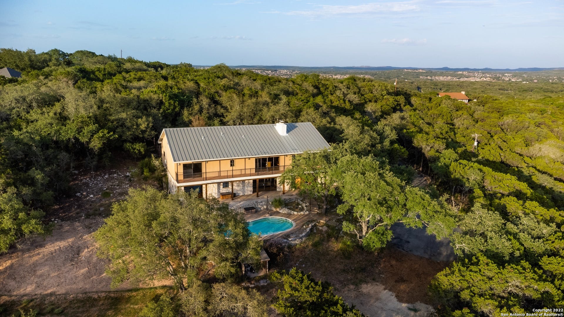 Welcome to the Boerne Hill Country at its best. This ranch style home stuns with 180-degree views that are some of the finest in town. Outdoor living space does not disappoint with pool, extra-large deck for entertaining and balcony that runs the entire length of the house, just so you can catch those amazing sunsets. The seclusion and tranquility start at the entrance of the property as you come up the long driveway and suddenly you are taken away from the hustle and bustle. Your very own gated 2.88-acre retreat. This beautiful home boasts spacious living in every room. 4 bedrooms 3 full baths 2 half baths. Two living spaces (one up and one down both with fireplace). Ensuite bedroom downstairs. Large Dining room. Great sized kitchen with island and walk-in pantry. Two additional bedrooms with shared jack and jill bathroom. Master bedroom with walk-in closet and attached bathroom. Every room takes in the spectacular views. Home has 2 car garage, new aerobic septic drip field system, excellent well water filtration system, water softener, and two extra-large Marathon hot water tanks, and HVAC system partially updated. Well has been updated. HOA is voluntary. Property set-up would be great as bed and breakfast. With this home you will be close to everything but feel like you've found paradise.
