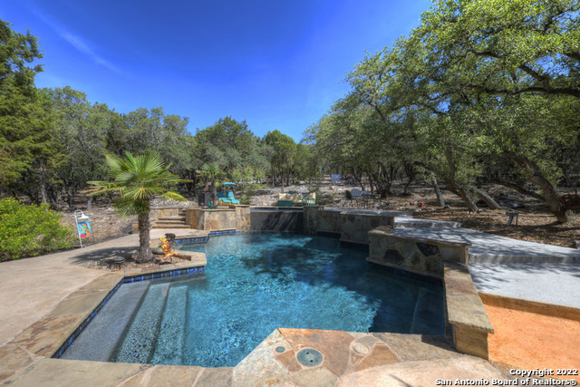 Incredible custom dream home on 2.5 acres with pool and sports court in Windmill Ranch!  This property is built for entertaining and relaxing. Gather with family and friends in the pool featuring a waterfall and tons of room for playing.  Or lace up the shoes for the full basketball court and pickleball court.  Chef's kitchen with double oven and granite counters opens to a gorgeous living area overlooking the backyard.  Private master suite with spa-like bathroom and 2 walk-in closets.  3 bedrooms upstairs with massive gameroom.  3 car garage, back patio fireplace, beautiful landscaping, 3 AC's, 2 tankless water heaters, metal roof, 1/2 bath with a floor made of pennies!!!  Indoor dog room and dog run, fully fenced back yard, oversized outdoor building that could be used as a shop/workout facility/game room or whatever you need.  Laundry shoot from 2nd floor to laundry room, and much much more.  One owner and truly a must see!