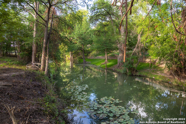 2.3 acres on the Medina River in the beautiful historic city of Castroville!  This 2175 sq ft, 3 bedroom, 2 bath home is perched atop the high bank overlooking a park-like river setting.  The large lot includes mature trees, a fully fenced garden area, and huge cypress trees along your own 186 ft of Medina River frontage.  An upstairs game room offers additional living space.  Hardwood in the living room, split master with jacuzzi tub, skylights throughout, gas cooktop and fireplace, walk-in attic space.  Brick exterior with all trim newly painted. Convenient to restaurants, shopping, dining, Lackland, and San Antonio. Great place for entertaining or just enjoying the view from the covered patio. This property offers seclusion without isolation. No HOA