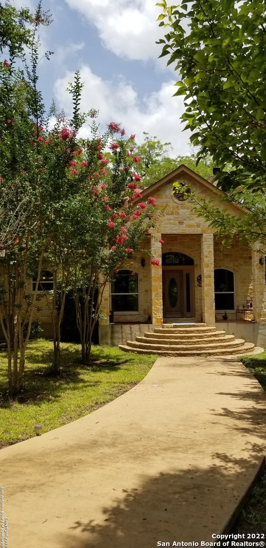 Texas Hill Country Home! Nestled under massive native pecan trees and only 15 miles west of Boerne and 30+ miles NW of San Antonio in the Heart of the Hill Country stands this 2800 sqft home on 3.22 acres. The home has a virtual view of Pipe Creek from the covered back porch. Covered front porch as well. The living,dining and kitchen area is open floor plan with high ceilings and large windows and doors that bring the outdoors inside and overlooking the yard and beautiful views of the creek.  It has 3 bedrooms, 2.5 baths and office. The master bedroom and bath has big windows, two walk in closets, whirlpool jet tub and separate walk in shower. Closets have custom built vanities. The guest bedrooms are separated by a jack & jill bath. The kitchen has custom cabinets with slide out drawers, granite countertops, nice long island with vegetable sink with disposal.The cooks stove is propane but is also electric wired. A hill country tile scene is behind the stove.  The dining room and large living room has a floor to ceiling native stone fireplace which is plumbed for propane or woodburning. The mantel is made of cypress. Great place for hanging Christmas stockings! On either side of the fireplace are custom built bookcases and TV.   The double carport has a storage room with shelves, hotwater heater and water softener.    Outbuilding:  A 30x50 metal barn/workshop has electricity and water. A RV shed 24x40 also next door to barn. A nice size garden is high fenced with fruit trees and grapevines. The seller is very proud of his jellies made from the grapes and shares it with friends. Adjacent to the garden is a pecar orchard with 25 trees that have begun to produce delicious pecans.    The water well is 460ft with a static level of 140 . Pump is at 380ft . It produces 65gpm. The septic is an aerobic system