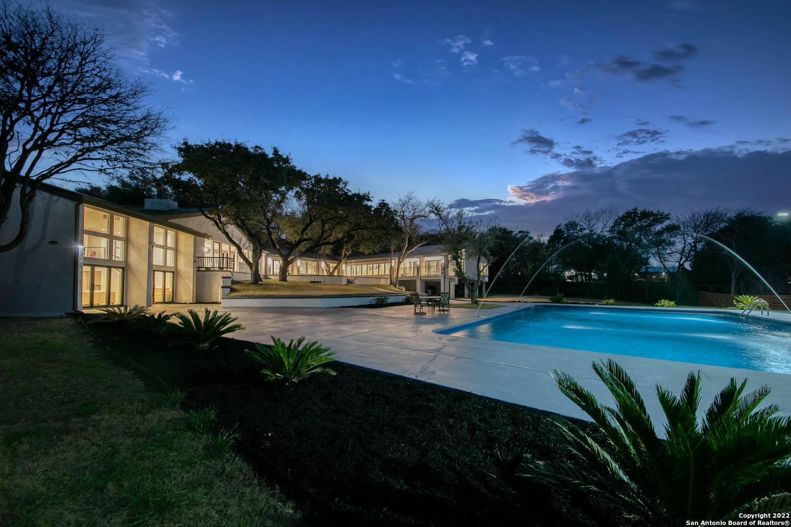 Introducing an exquisite, magnificent, luxury mid-century modern grandeur estate located in the Alamo Heights Independent School District! Skillfully placed in the back of a deep-set front lawn and shaded by mature oak trees, this gorgeously renovated and redesigned one-level architectural marvel boasts of aesthetics rarely available in modern homes. The amalgamation of modern features with historical details are a well-kept secret of this palatial marvel that offers the utmost security, serenity, and privacy.     The grandiose master suite boasts of a stupendous walk-in closet, soaring ceilings, designer bathroom with mighty marble-ensconced spa-like bath & glassed-in shower, vessel tub, double quartz topped vanity, and an attached porch that overlooks the colossal pool and a carefully manicured backyard. In addition to the four bedrooms and a gourmet kitchen with an oversized island & a spacious butler's pantry, the home boasts of two massive living rooms, dining room, study room, and a flex room. Experience serene indoor-outdoor living through sweeping panoramic windows and sliding glass doors that open onto an incredible idyllic backyard oasis comprising of expansive patios & four beautiful terraces covered with mature oak trees and a cosmic pool with ~65,000 gallons of sparkling water & fountains.     The hallmark of this property is an open floor concept accentuated by natural lighting through nearly 70 expansive windows, sophisticated modern interiors with utmost attention to details, high ceilings, generously sized rooms, three beautiful stone fireplaces, and suave white oak and marble floors. Presence of soundproof doors and windows, four air-conditioning zones and double roof makes this home energy efficient. Essentially your own private resort on an oversized 1.27 acre lot in the heart of San Antonio, this refined residence provides the perfect union of design, lux livability, and privacy. Proximity to I-410 makes the location of this property very convenient to access downtown, medical center, quarry marketplace, two large universities, the airport, and major schools (AHISD and Saint Mary's Hall). It's a true rarity & must see!