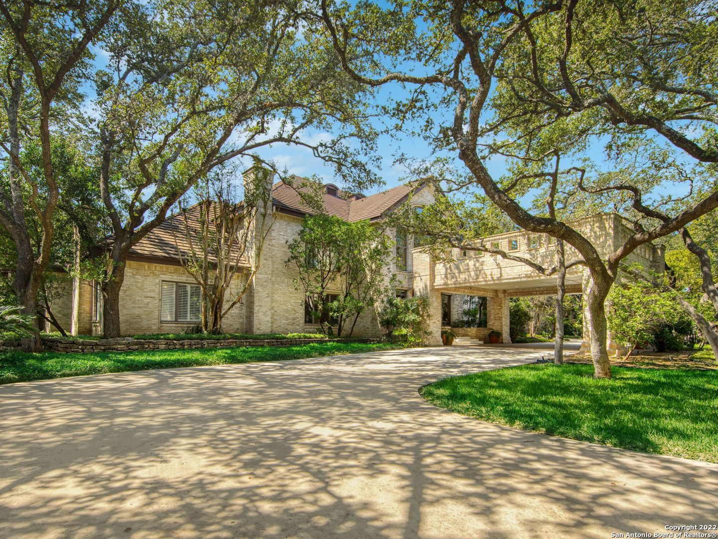 Hidden within the quiet community of Hill Country Village and behind the formidable gated entry connected to high walled perimeter is the expansive 6.81 acres of over 300 hundred mature oaks that cover this uniquely peaceful property. Distinctive design replete with exceptional elements. Superior craftsmanship and only the finest appointments found in the main home including the walls of windows illuminating the interiors revealing exquisite solid wood millwork throughout, custom ceiling details and chef's kitchen complete with custom cabinetry coupled with large Brazil-mined rare quartzite island. Relax in the oversized master retreat with a spa-like bath overlooking the backyard oasis. The remaining guest bedrooms found upstairs are spacious and luxe. Poised for large-scale entertaining a full prep kitchen with extensive cabinetry is found through the breezeway and features a fully equipped gym. Impeccable craftsmanship prevails with a detached casita complete with a large living room and kitchenette. A three-bedroom guest house is complete with extensive storage space, oversized living room space for guests, and a full kitchen with a kitchenette up. Escape to the palatial spread of the property and take relaxing walks amongst a park-like setting with a full sports court and playground with a custom-built treehouse. A sparkling pool and spa with full summer kitchen nearby make this an entertainer's dream. A true outdoors oasis with pristine landscaping blending naturally into the surroundings offering the perfect backdrop throughout the residence. Privacy is exemplified with Hill Country Village's own 24-hour police force and a 10-minute drive to the San Antonio International Airport. Exuding extraordinary charm, the possibilities are endless with this rare opportunity to own one of Hill Country Village's most exclusive properties.