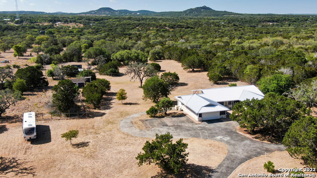 **MOTIVATED SELLER - ALL OFFERS CONSIDERED** Claim your piece of Hill Country heaven with this impressive ranch style home! Bringing luxury living to the rugged hills of Texas, this modernized 4 bedroom, 3 bathroom scenic sanctuary sits on ten fully fenced acres of unrestricted land. This peaceful retreat boasts unparalleled privacy and unsurpassed views, all with the conveniences of "city life" just a short drive away; Homeowners will be just 20 minutes away from Bandera, 25 minutes away from both Alamo Ranch & Boerne, and 1 hour away from Kerrville. Enter through the secure, electronic gate and continue towards your residence via a circular driveway that offers convenience and curb appeal. A large courtyard gives an attractive twist to the entrance of the home and offers countless possibilities to reflect your personal style. In addition to the circular drive, extra parking is adjacent to the garage - large enough for 4 vehicles, RV's, boats, tractor trailers - whatever you need! Step inside and it immediately becomes apparent that no detail has been overlooked! An updated coat closet greets you with an aesthetically pleasing storage solution as you enter the home, where oversized windows allow for natural light to flood the interior. Adjacent to the entrance lies a bonus room, perfect for an at-home office, playroom, or guest suite as it sits separately from the primary and secondary bedrooms. Just beyond the entrance is the main living area and dining space, seamlessly connected to entertain with ease. Serving as the centerpiece in the main living area, a custom built fireplace and mantel were masterfully designed to bring a feel of modern elegance to the space. If you're looking for dinner with a view, you don't have to travel far; Elegant french doors, flanked by large picture windows provide you with a beautiful, unobstructed view of Texas' rolling hills--- all from the comfort of your dining table. The kitchen is a chef's dream and offers ample counter & cabinet space, stainless steel appliances, 36" induction cooktop, double wall oven, decorative tile backsplash, butcher block countertops, new cabinetry with soft close hinges and double drawer system, and updated fixtures and finishes--Though currently not being used as an eat-in kitchen, it is certainly large enough for additional dining space! Off of the kitchen sits a utility room w/ access to ANOTHER bonus space (spray foam insulated and fully heated & cooled) where you can house your home gym, craft room, plant room, etc. Residing on the opposite side of the house are three comfortable and well appointed secondary bedrooms, two completely upgraded full baths, and the primary suite. The two secondary full baths have the same level of luxurious detail found throughout the rest of the home, and are comprised of upgraded vanities, fixtures and finishes, and stylish decorative tile work. Retire to your own personal oasis in the primary suite, which highlights two walk-in closets--one of which features a custom closet system--and a lavish spa-like bathroom that you will never want to leave. Perfect your morning and evening routine, this ensuite bathroom showcases two separate vanities, an oversized, free standing soaking tub where you can enjoy a glass of wine while watching the sun set below the hills, and a MASSIVE walk-in shower. The exterior of the home is just as impressive as the interior with a partially covered, 560 square foot custom built deck that spans almost the entirety of the back side of the house. If that wasn't all, this property also features a split 3 car garage with two entrances, a new chicken coop with electric and water, and 3/4 acre fenced chicken run with flock included. A true masterpiece, this captivating home is nothing short of spectacular! All server racks/wireless access points are included. Refrigerators, washer & dryer (purchased new in 2022), zero-turn mower, John Deere tractor w/ bush hog all negotiable items.