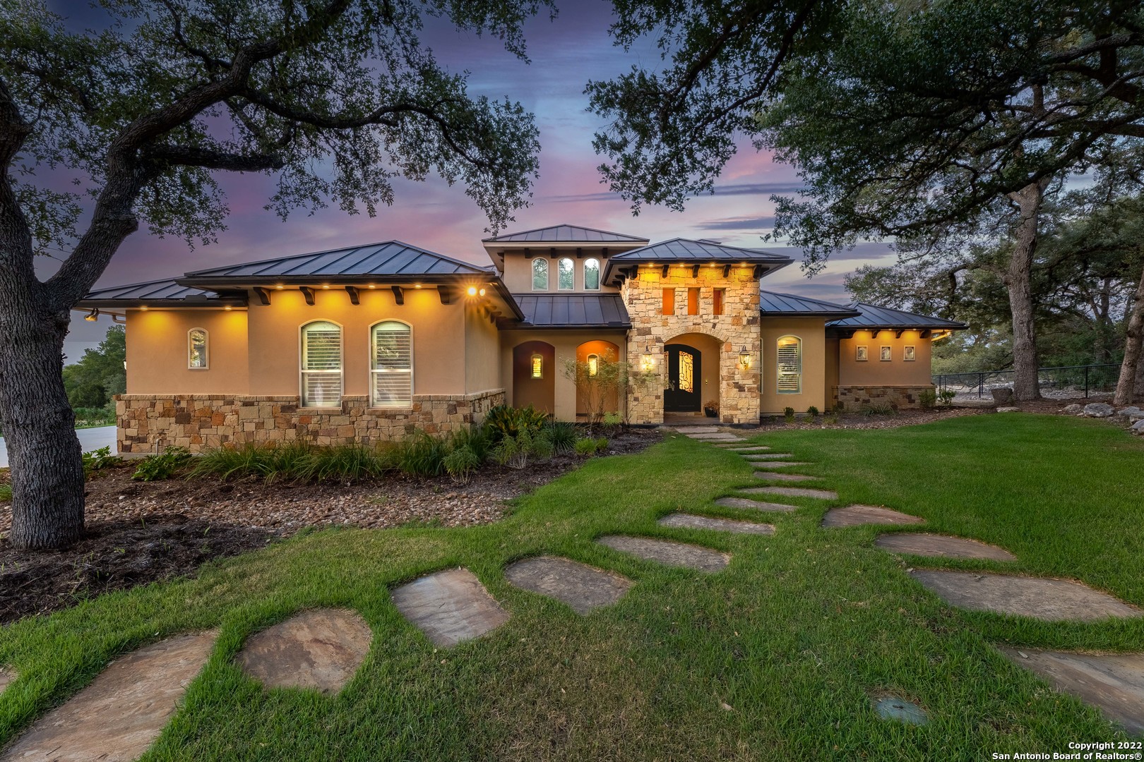This stunning contemporary hill country home was constructed on a grand scale that exemplifies Texas Luxury in the amenity heavy and highly sought after Vintage Oaks. A vast property set back in a private area entices you through the large formal entry leading you into the heart of this home with an expansive and elegant kitchen that will check every box imaginable. The dining room is accompanied by large windows that view the park-sized backyard, and the living room is fitted with a stone fireplace, built-in shelving, and open to the massive covered porch, complete with an outdoor kitchen, ceiling fans, and solid countertops. The Primary Bedroom and one extra bedroom are situated on the main level with dedicated bathrooms. The primary bath includes dual vanities, a soaking tub, and a large walk-in shower with built-in seating. The best part of this opulent primary suite could be the walk-in closet. Other outstanding features include a tremendous sized office with built-in desk and shelving, a media room fully functional and ready to view, 2.5 baths on the main level, a laundry room with plenty of space and storage, three-car garage, circular drive, top of the line appliances, extra game room upstairs, and double-desk off of the main living area. The amount of life this home has and will comfortably contain is formattable and done with ease. It is a property that will meet the needs of many and offer a lifestyle few can. This doesn't even begin to touch on the community itself and what it has to offer. So bring your life and settle in.