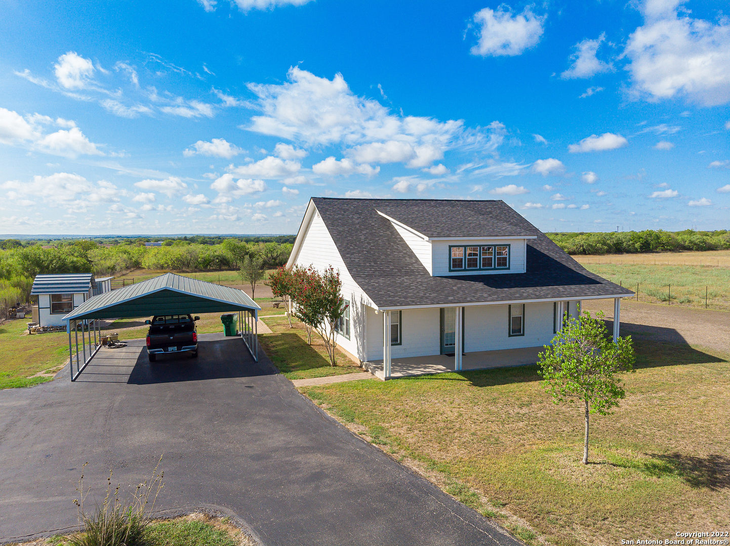Ideal Texas Ranchette on 5.5 acres! (Outside city limits) The house with 1 acre is fenced separately. This is the perfect location for the commuter. Very close to IH10 on the San Antonio side of town.  The home itself is Beautiful and very well-maintained -it includes 2 Bedrooms with 2 full Baths. The kitchen overlooks the majority of the property and is a chefs dream! Loaded with windows and sunlight plus a full island prepping area and custom cabinets! All of the rooms are large with plenty of possibilities! Very open floor plan! There is also a front and back covered porch for enjoying your mornings and evenings. The property is completely fenced and has an electric gate entrance.  Updates include home exterior Painted 5 years ago and new roof 7 years ago. There is also a 2 car carport and 2 storage buildings. This property is very lightly restricted.