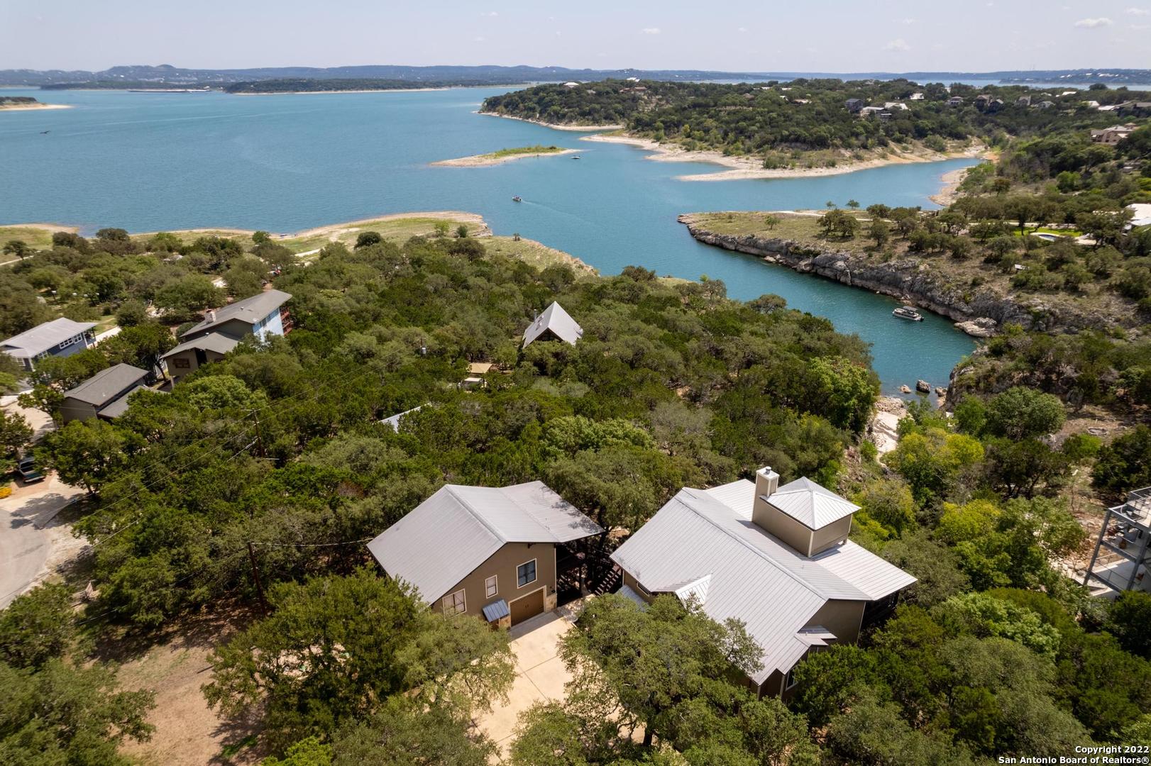 LUXURY WATERFRONT HOME & WATER ACCESS! Treehouse atmosphere above one of the most beautiful cliff coves on Canyon Lake.   Well appointed custom home and guest house for entertaining long term guests, or your own solitude and wellness. Multiple decks for relaxation and privacy.  3 car garage.  Unplug, unwind in all the best nature has to offer! Check out the virtual tour and the aerial views! AGENT OPEN.