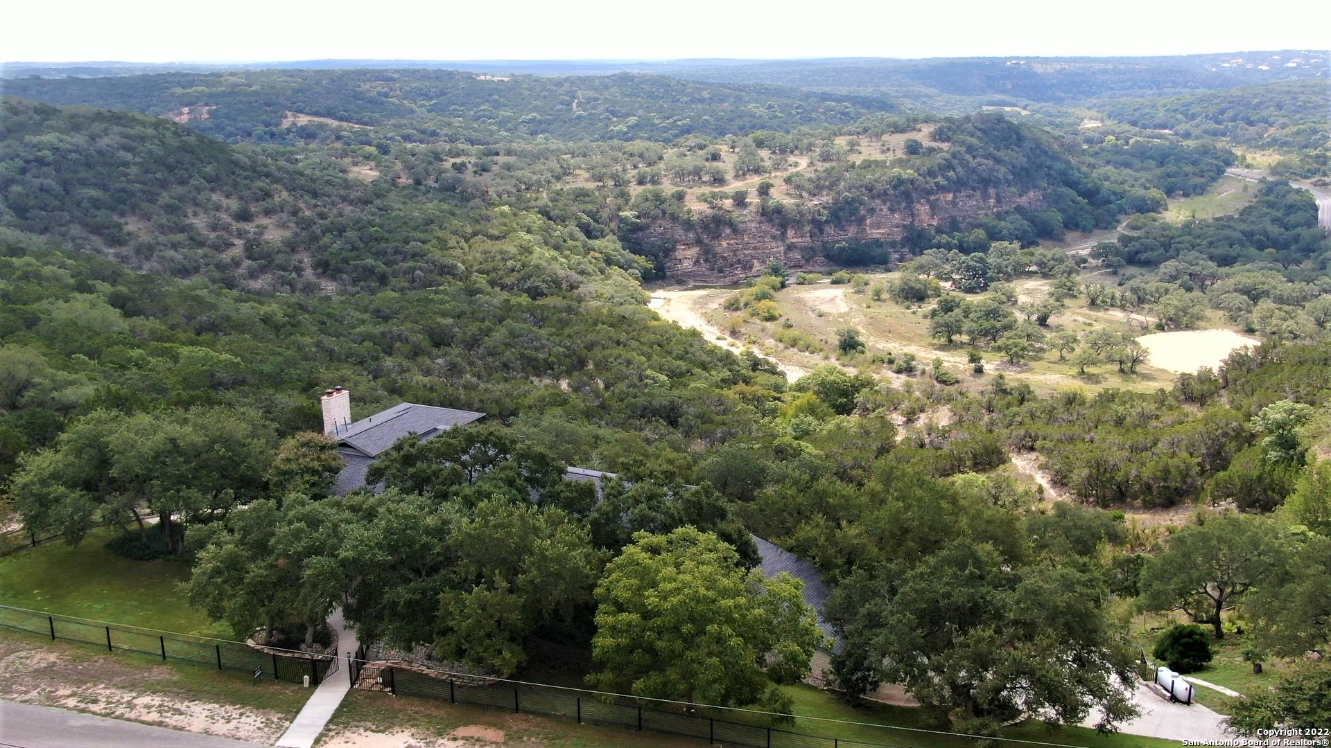 Contemporary Hill Country Masterpiece! This custom home designed by Award Winning Austin Archcitect, Tim Cuppett, captivates with an understated, sexy sophistication. The refined, timeless style is well-executed to complement, and not compete against the alluring outdoor elements, overlooking the Cibolo Creek and Canyon. Upon first step into the foyer, the soaring ceiling, brilliant architectural design and gorgeous hardwood maple flooring create an instant WOW factor. And, let's talk about the aesthetic charm of all the wood-framed windows!!! The split-level layout allows for opportunities to enjoy the beautiful hill country from almost every room! The great room includes a full limestone wall & fireplace with space for several conversation areas. The dining room is open to encourage a relaxed & enjoyable ambiance. The sleek galley kitchen boasts long granite counters, 2 sinks, stainless appliances including a Thermador 6-burner gas range with convection oven. The master suite features a gas fireplace, full bathroom, walk-in closet & private balcony. The office possesses a lofty vibe, complete with built-ins, a corner window reading nook & is conveniently located near the master suite. The secondary bedrooms, bathrooms & living room can be found tucked away on other levels. The multi-tiered, hillside decks provide plenty of spots for coffee at sunrise, yoga, dinners al fresco & shaded evenings with drinks & entertaining. I dare you to find a spot that doesn't provide you with incredible, breath-taking views of the canyon! This gated property is near the end of a cul-de-sac, feeling hidden & private. No city taxes! Conveniently located between New Braunfels, San Antonio and Boerne.