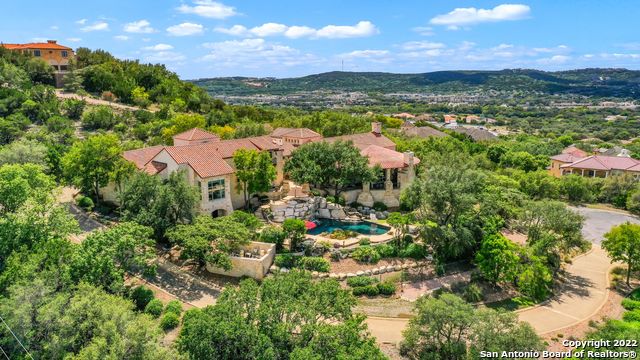 Unparalleled craftsmanship! Located on a 3.33+- acre hillside lot this perfectly situated home relishes the awe inspiring 180+ degree Texas Hill Country views from every room! This architecturally significant Dominion home is one-of-a-kind, and was designed by renowned architect, Roy Braswell, and built by master builder, Image Custom Homes. The finest appointments throughout are fit for the most discerning buyer. Grandeur open living space is appointed with vaulted ceiling, floor to ceiling stone fireplace and opens to dining room with doors opening to expansive covered patio. Entertainers dream kitchen with Sub Zero appliances, custom cabinetry, and large center island with breakfast bar, is adjoined by wet bar and separate caterers' kitchen with extensive storage and secondary dishwasher. Primary suite offers outdoor access with its own covered patio and generous ensuite bath boasting natural stone elements, multiple vanities, built-ins, two closets, and soaking tub overlooking serene private yard. 3 secondary bedrooms are on the first floor, each with their own ensuite bath and breathtaking views. Spiral staircase leads down to entertainment level with game room, bar, full bath, and pool access. Impressive deep-water Keith Zars pool offers spa, multiple water features, diving ledge, and pristine flagstone decking providing ample poolside living space. Private drive, motor court, and three car garage provide ample room for all your toys.