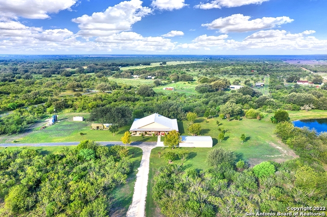 Fully furnished gorgeous, well built home on 12 acres in D'Hanis, TX! From the massive tank to the majestic oak trees and maintained yard - the outdoor space is completely serene. You will also find a 24x40 barn, greenhouse and workout room. Under roof is 80x80 with 3600 square feet of living space and 2800 additional sq ft of covered wrap around porches! The interior space is just as impressive with beautiful wood floors, a double island kitchen with 3 sinks, double sided fireplace into the owner's suite as well as a safe room with interior gunsafe. You'll also find a secret storage room behind a huge sliding decorative wood door in the dining room, 10' ceilings throughout, and an amazing butler's pantry. Deep Edward's water well and water softener on property as well. Additional acreage available. Get ready to enjoy county views and sunsets on your amazing porch!