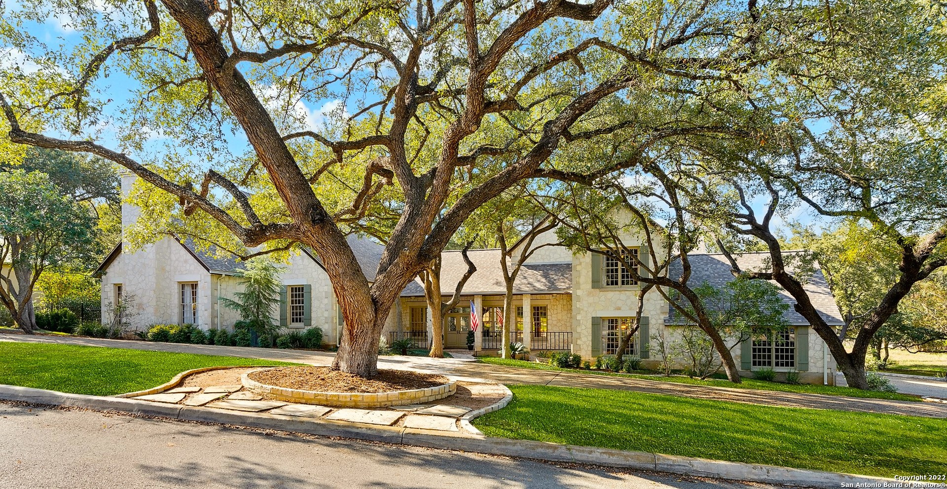 RARE FIND! This renovated Hill Country- style estate shines with understated elegance & is conveniently situated on a .92 acre tree-studded lot in the heart of the city on exclusive Parman Place.  Upon entry - you will notice the stunning architectural details at every turn to include 25-foot beaded board cathedral ceilings; leaded glass front door and transom windows over most all interior doors; Marvin wood, divided light windows; rich, quality wood trim, cabinets and paneling and rooms that showcase grand space & scale. The chef's kitchen features a newer (3y) Subzero fridge/freezer & appliances, walls of gorgeous cabinetry and miles of granite countertops and is open to a sunny living space with fantastic limestone walls and views of the garden.  A coveted secondary suite downstairs is near the kitchen & makes for the perfect guest hideway.  The nearby dining room provides a built-in breakfront with counter and cabinets for abundant storage.  Your guests can flow right to the kitchen, family and dining spaces or left to the grand living room with bar area and floor to ceiling limestone fireplace or straight outside to one of the many patio areas.  Stop by the executive study - complete with rich wood built-ins and closet with surprise inside.  Continue past the study to the stately primary suite with fireplace and a spa-bath sure to please with two vanities, soaking tub, roomy shower & two closets. Enjoy the private patio outside the primary bath for your morning coffee or evening cocktails.  Please do notice that the lower level also provides two half baths for convenience.  Upstairs delivers another living area and two very spacious bedrooms.  To the left is a suite with a huge closet and balcony overlooking the backyard and to the right is an enormous bedroom with jack & jill bath.  Upgrades include wood & travertine flooring (no carpet except primary closets); appliances; countertops; bathrooms and newer HVAC units. Peaceful paradise awaits outback with multi-patios, pergola-covered hot tub; no neighbor to the right (ownership of nearly half that lot is included) and a greenbelt.  Realize plenty of room to design your dream pool.  Large, fenced dog area or garden area to the left of hot tub. Parking is a breeze with your side-load, oversized three car garage and long, graceful circle drive.  Come for a visit and plan plenty of time to be amazed.