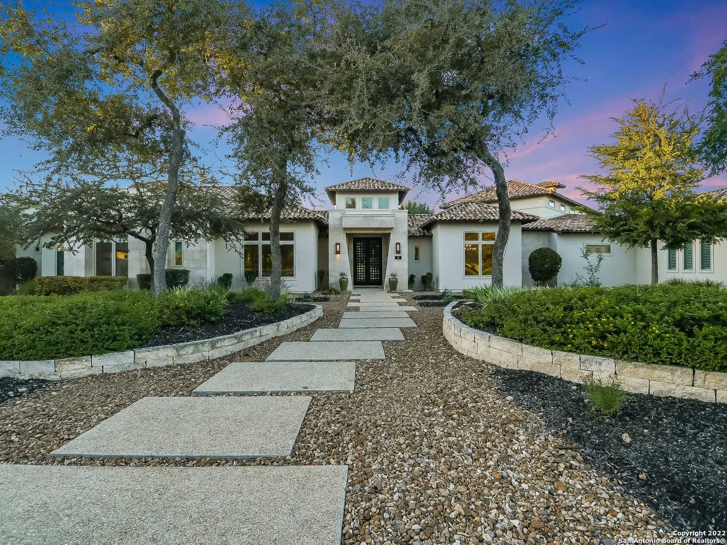 This award winning single story masterpiece is positioned perfectly on the 1.19 acre lot to take in the stunning hill country views while maintaining privacy. The over 6,000 sqft home features design elements that showcase the open floor plan with walls of sliding glass doors that seamlessly integrates indoor and outdoor living. The chef's kitchen features top of the line Thermador appliances, an expansive custom island that flows into the living room with soaring barreled ceilings, a stone wrapped fireplace and large breakfast room. The oversized master suite boasts a spa-like bath with a double marble shower, stand alone soaking tub, multiple expansive walk-in closets and an exercise room with outdoor access. Each of the 4 additional bedrooms feature an on-suite bathroom and walk-in closet. Additional features include the spacious home office overlooks the pool, coved ceiling dining room, 200 bottle wine rack and the generously sized game room that boasts a wet bar creating an entertainers dream. The outdoor covered patio is outfitted with an outdoor kitchen and custom automatic screens that protects the dining experience from bugs with the press of a button. The resort-like grounds feature an infinity Keith Zars pool & spa, fir pit, sports court for pickle ball or basketball, and a pollinator garden. Gorgeously designed by Gustavo Arredondo and built by Burdick Custom Homes in 2016, this property must be experienced in person to be able to take in all it has to offer.