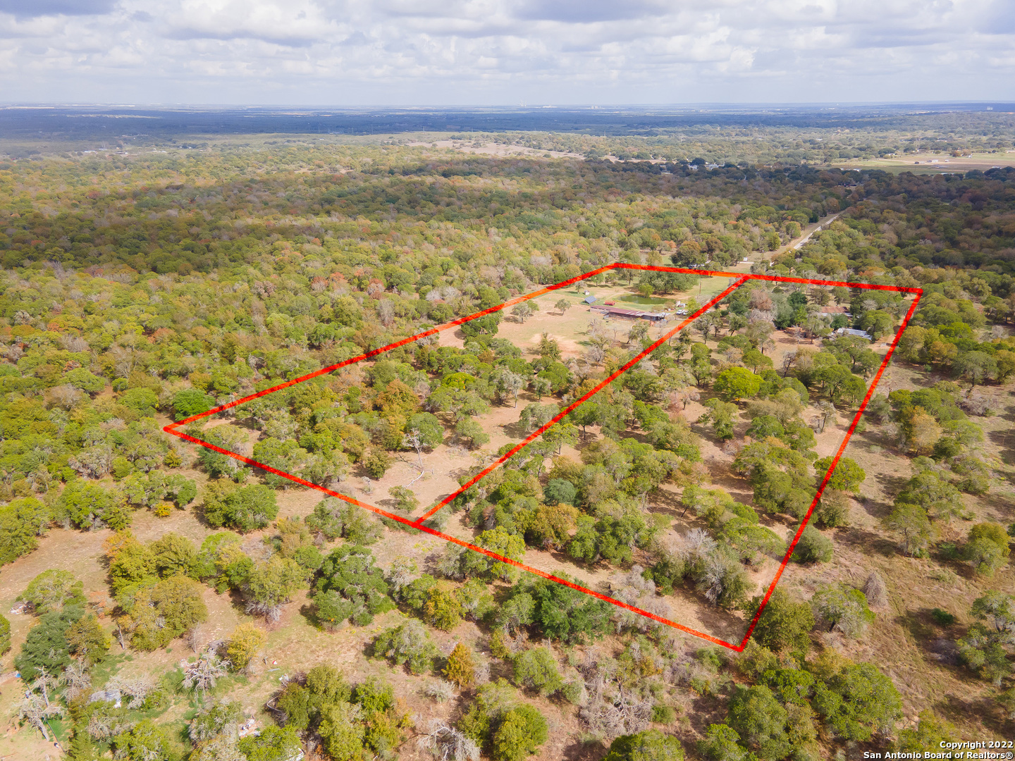 Are you ready to slip away from the city life, noise, and traffic? If so, this is the place for you! 21+ Ag exempt acres in San Antonio, TX, just off Hwy 1604.  No restrictions or city taxes.  Great location with endless possibilities! The view is amazing with a stock tank pond sitting in the middle of the field. This unique property also includes a 6 stable horse barn, 8 dog kennels with runs, and chicken coops. The home home is a three bedroom with two full bathrooms and is equipped with 24 solar panels. This property also has an additional space for a second home with electric and septic already in place.  The entire property is fenced and cross fenced for livestock.  Current Manufactured home on the property does not convey with the sale.