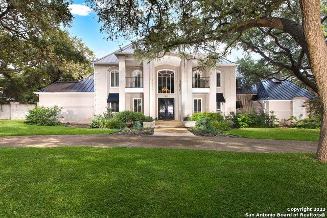 Located in the prestigious, tree-lined streets of Shavano Park, this private estate sits on over an acre of land, surrounded by countless mature oak trees. The property was impeccably constructed to the highest standards offering a balance of elegance and comfort whilst marrying sophisticated architecture with a touch of traditional charm. A grand foyer leads you past the stunning dining room to an oversized office with double doors and custom built-in desk, shelves, and cabinets for the work-at-home executive. The craftsmanship utilized in this one-of-a-kind home is evident in the impressive formal living room with 18-foot-high ceilings, a fireplace, and refinished oak wood flooring. In addition, the light-filled living room provides a picturesque view of the spa-like pool and private backyard. The covered patio space is conveniently located next to the brand-new outdoor kitchen with granite countertops, a built-in grill, and an outdoor sink. Enjoy the pickleball court surrounded by lush landscaping. Enjoy the fully remodeled chef's kitchen with the built-in Thermador refrigerator, Viking appliances, and custom cabinetry. The expansive countertops, multiple stainless-steel sinks, six-burner gas cooktop, and functional layout provide the perfect kitchen for entertaining. The oversized secondary living space provides another spectacular view of the backyard, as well as an additional fireplace. The primary bedroom features a serene view of the backyard, sitting area, and fireplace. The spa-like bathroom offers a large soaking tub, separate shower, dual walk-in closets, towel warmer, bidet, and separate marble vanities. The bonus exercise space with installed mirrors for yoga and fitness routine is an added feature to the spacious and functional primary bathroom. The upstairs game room offers sound-absorbing cork flooring for movie nights, poker games, a pool, and more. The game room includes a custom wet bar with a sink and beverage refrigerator, bookshelves, and ample storage space. One of the bookshelves opens to the hidden "secret room" with a large storage area. Several of the additional bedrooms include ensuite bathrooms and/or private balconies with stunning views. All the bedrooms are spacious, have scenic views, and include large walk-in closet space. This stunning home features a wonderful amount of storage, privacy, and amenities and is ideally located near BASIS, USAA, 1604, I-10, Wurzbach Parkway, Medical Center, Alon Town Centre, Hardberger Park, and numerous restaurant/retail destinations.