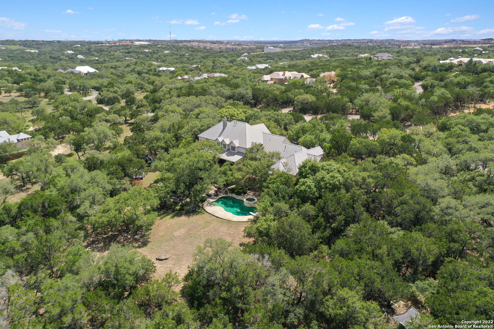 A Magnificent Texas Hill County Inspired Architectural Gem is a destination retreat ready to call home. Positioned on 2.78 acres in Guarded and Gated Sendero Ranch. Only 6 exits away from 281/1604 and just minutes from the airport. Beautiful windows and high ceilings welcome you at entry. Grand Gathering Family Room, Dining and Kitchen situated next to downstairs gameroom. Gourmet kitchen with large island, gas cooking, beautiful cabinetry opening to the family room and view to sprawling back yard and pool views. Spacious Master Suite w/luxurious master bath and dual closets. Everyone will be talking about the warm & inviting Hand Hewn log game room with fireplace and bar. Get ready to take your conversation to a whole other level. The Backyard is your oasis of peace providing privacy, lots of trees, space to run, pool, spa, fireplace and large covered patio with outdoor kitchen. It's ready for you to unwind and call it home.