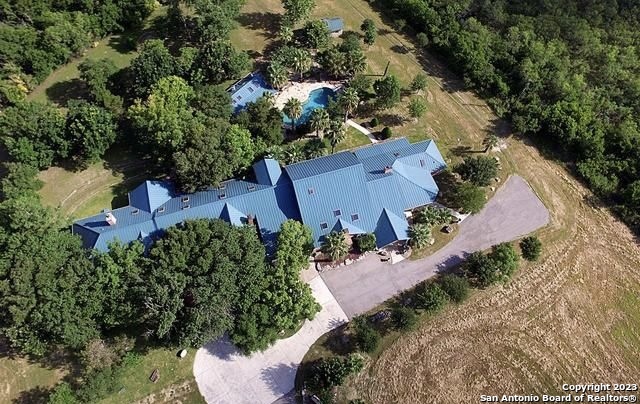 Prime location off I-35N & Watson, b/t SA & Austin. NO HOA!  3 phase build: 1987, 2003, 2010.    Upon entering gates, a tree-lined drive leads to beautiful 18ac oasis w/ unique ranch style home & countless amenities. Among these amenities: 3 full kitchens, gym w/sauna, 4 indoor fireplaces & 1 fireplace in pool house, with full kitchen, dining area & half bath; green house, barn w/ tack room, pole barn, stock pond. Event/entertainment room and full bar area. Gorgeous finishes w/ 20' vaulted ceilings & skylights throughout nearly 12,000sf.     Besides various multi-purpose rooms, there is a particular blank slate that could be an incredible media room - or competition size racket ball court. Whatever you can dream up, it's ready to come to life! The stock pond hosts various wildlife. With a 4-stall barn, tack room & round pen, it's perfect for horses, but suitable for just about any livestock. Ag friendly.     Hot tub incl'd. ***Gym equipment, furniture, patio furniture, etc. all negotiable.    Adjacent 12acres also for sale. Same seller - could make for great packaged deal!   SABOR MLS: 1661715