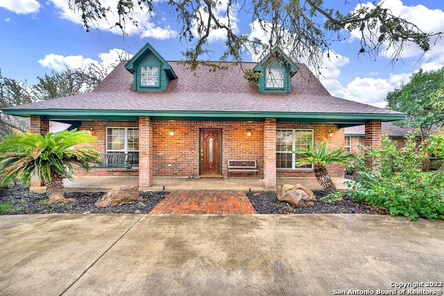 Be ready to be blown away by this unique hidden gem located in Hondo. This 4,200 square foot brick home has endless possibilities. As you enter through the front door you will be greeted by a large living area with a gorgeous brick fireplace. Off of the living room you will find a mudroom to one side and a sunroom to the other, both lead outside.  One unique feature about this home is that it has two kitchens! There is also an entertainment room with a projector and screen, the perfect room for entertaining guest.  The huge laundry room gives you plenty of storage space for cleaning supplies or a side hobby.  The oversized master suite located on the first floor offers a sitting area along with a built-in desk.  Two rooms and a full bathroom are tucked away upstairs.  In the back yard you will find the coolest custom train playset along with a covered seating area, inground pool/spa, cross fenced immaculate yard, private well, storage shed and so much more.  You are not going to want to miss this, schedule your showing today!