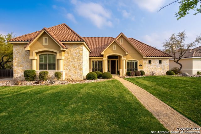 Explore this opportunity to own a newly updated 4 or 5 Bedroom | 5 Full Bath | 3 Car Garage, 1 1/2 story home, in one of North San Antonio's most premiere Golf Course communities. The sanctuary is nestled behind a Guarded Gate, with Central Park (an owners park); plus, a world class Amenities Center and Private Golf Club (memberships available), located just outside. Relax year-round on the large, covered patio, surrounded by lush landscaping with a bubbling Waterfall Pond that completes the private garden-like yard.  All, with the added perks of Reagan High School, and No City Taxes. The primary bedroom features a luxurious bath with an oversized walk-in shower, large jetted tub, double vanities, an ample closet, and retractable black-out shades.  The home is built for entertaining with a large formal dining room and flex room. Live well under impressive barrel and tray ceilings.  Imagine galley lighting, custom cabinets, a gourmet island kitchen, breakfast bar, and a breakfast room that pour into the grand room, where a corner rock fireplace soars to the high ceiling above, plus 2 secondary bedrooms on the first floor, for all your guests.  All bedrooms enjoy their own full en suite bath. The half story upstairs, is a suite of its own, with a large living area, bedroom, and full bath.  Other savvy architectural elements include a mud room/study room leading from the garage to the kitchen, and a downstairs bath opening to the back patio; ideal for a swimming pool the new owners may add. Storage abounds with the attic wrap-around, encircling the upstairs game room.  Top notch area amenities include boutiques, restaurants, shopping, entertainment, and direct airport access.  4110 SF.  Office is 5th bedroom/flex room. Ask for extensive list of recent improvements. Supremely well maintained, with service records available.  $10K Decorator Allowance to use at buyer's discretion.