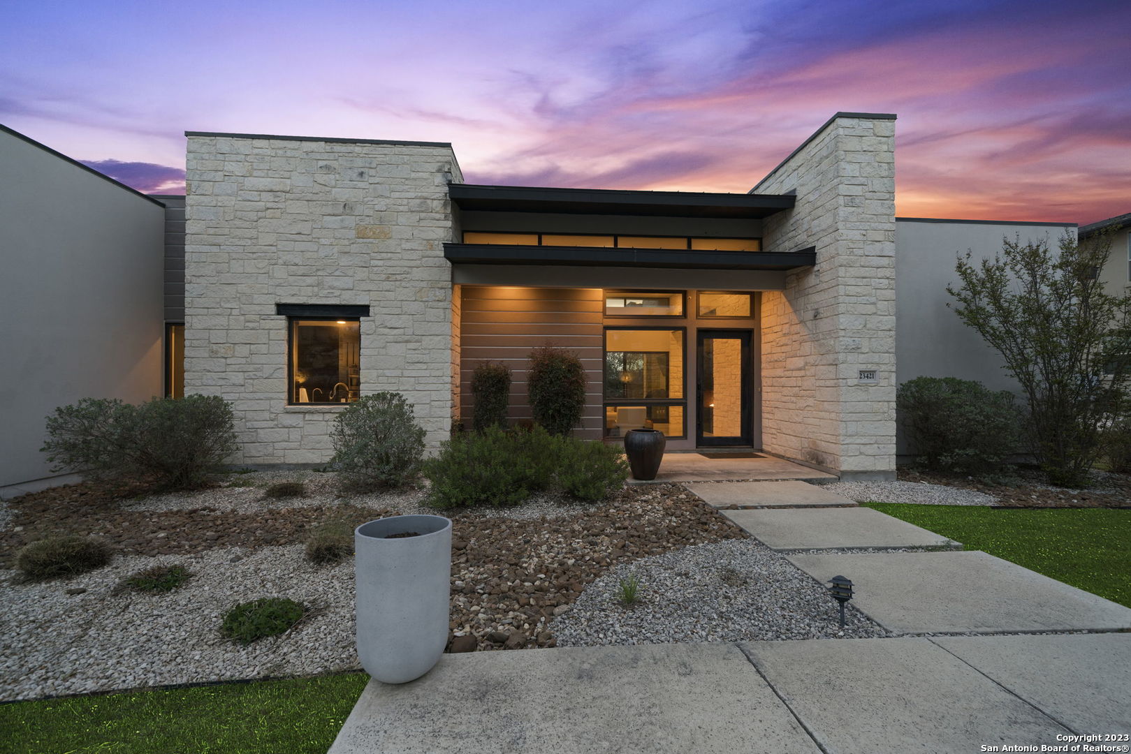 Welcome to this stunning contemporary home built by Adam Wilson, featuring 3 bedrooms and 3 bathrooms and a half bath, located in an elevated position that offers breathtaking hill country views.    As you enter the home, you'll immediately notice the 10-foot high ceilings that create an open and spacious feeling throughout the home. The living area is even more impressive with its soaring 14-foot high ceiling, which is sure to impress anyone who walks in. The room is bathed in natural light thanks to the floor-to-ceiling windows and sliding doors that lead to the backyard, where you can enjoy the beautiful scenery.    The gourmet kitchen is a chef's dream, featuring top-of-the-line appliances, custom cabinets, and a long oversized island that's perfect for entertaining guests or just relaxing with family. The kitchen also has plenty of storage space, so you'll never have to worry about clutter.    The master bedroom is a luxurious retreat with a sitting area, his and her closets and large windows that offer stunning views of the hill country. The master bathroom is equally impressive, featuring his and hers toilets and vanities, as well as an incredible shower with several heads that will make you feel like you're in a spa.  The concrete floors throughout are easy to maintain and extremely durable.  As you stroll through the home you'll find two en-suite bedrooms which are perfect for the privacy of your guest. There's an additional living space to relax, watch TV or play your video games.  The landscaping is truly amazing, with carefully curated plants and trees that perfectly complement the natural beauty of the surrounding hill country. You'll love spending time in the backyard, where you can relax and enjoy the peaceful surroundings with no neighbors behind you.   Overall, this contemporary home is a true masterpiece, built with quality craftsmanship and attention to detail. It's perfect for those who appreciate modern design and love to entertain, and it's sure to impress anyone who steps inside. Don't miss out on this incredible opportunity to own your dream home!